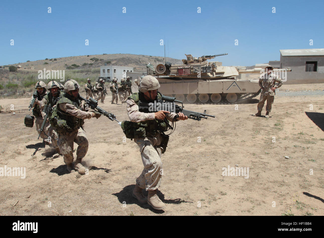 Kanadische Soldaten mit 2nd Battalion, Royal 22. Regiment, Umzug in eine städtische Schulung während ein M1A1 Abrams-Panzer während der Übung Dawn Blitz hier, 21. Juni 2013 Sicherheit bietet. Kanadische Soldaten koordinierten Bewegungen mit Marines aus 1. Panzerbataillon, mock Dorf von feindlichen Rollenspieler zu löschen. Dawn Blitz 2013 ist eine Szenario-driven Übung, Navy und Marine Corps Forces Marine Expeditionary Brigade (MEB) und Expeditionary Strike Group (ESG) Ebene zu testen, während die Förderung-militärischer Zusammenarbeit und Interoperabilität mit Partnern betriebene Nationen entwickelt. Sene Stockfoto