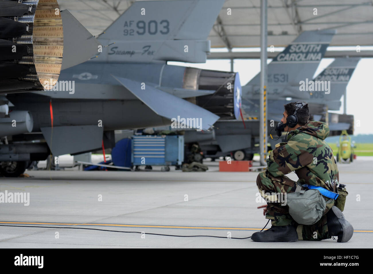 US Air Force Airman 1st Class Stephen Baran, Crewchief mit 169. Aircraft Maintenance Squadron, South Carolina Air National Guard auf McEntire Joint National Guard Base führt Vorflugkontrollen auf einem Kampfjet f-16 Fighting Falcon Block-52, taxi und für eine Mission während einer Bereitschaft Übung, 13. Juli 2013 starten. Mitglieder der 169. Kämpfer-Flügel bereiten sich auf eine zertifizierte Bereitschaft Bewertung, die bewertet die Fähigkeit eine Einheit zu verarbeiten, Personal und Ausrüstung vom Hause entfernt an eine bereitgestellte Position sicher und effizient, dann bedienen und Missionen in einem chemischen com zu starten Stockfoto