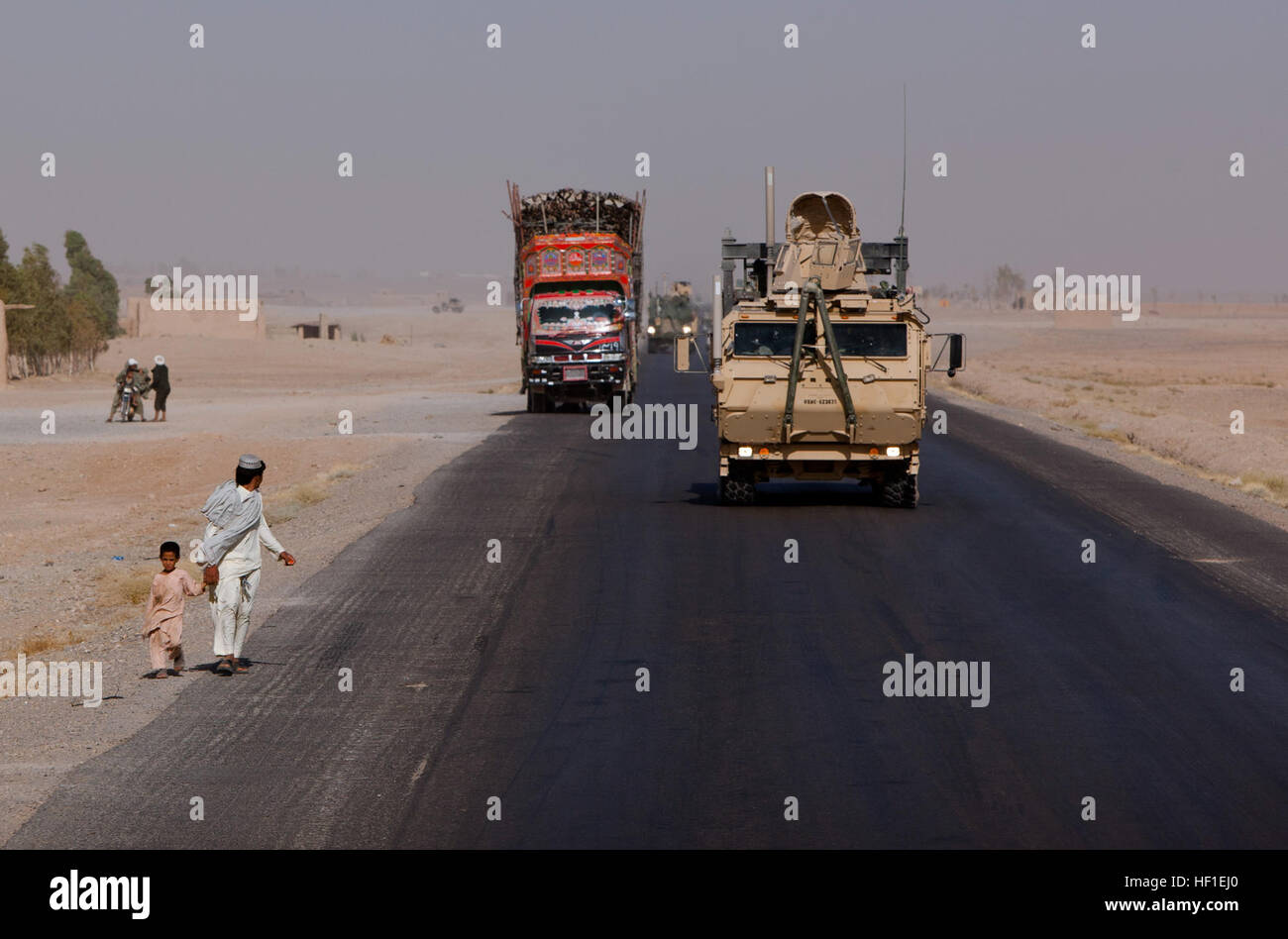 Ein Logistik-System Fahrzeug Ersatz Traktor nähert sich zwei afghanische Fußgänger während einer Bekämpfung Logistik-Patrouille unter der Leitung von Combat Logistik-Regiment 2, Regional Command (Südwesten), 22. August 2013, in der Provinz Helmand, Afghanistan. Mehr als 30 Fahrzeuge nahmen Teil des Konvois, die gleichzeitige Unterstützung vorwärts Operating Bases Shir Ghazi und Shukvani zur Verfügung gestellt. CLR-2 Konvoi testet Logistik Umschlag 130822-M-ZB219-178 Stockfoto