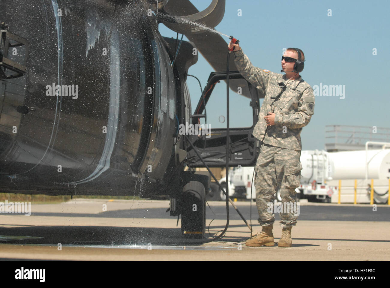 US Army Spc Jonathan Regan, der Firma D, 1. Bataillon, 137. Aviation Regiment, 38. Combat Aviation Brigade, sprüht von der Seite des UH-60 Black Hawk während Motorreinigung, 4. September 2013 bei der Army Aviation Support Facility in Shelbyville, Indiana (U.S. Army National Guard Foto von 1.. Lt. Tyler Mitchell/freigegeben) Motor Reinigung 130904-Z-JR812-002 Stockfoto