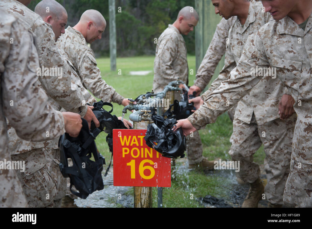 Rekruten von Fox Company, 2. rekrutieren Training Bataillon, spülen Sie ihre Gasmasken nach chemische und biologische Kampfstoffe Verteidigung training 24. September 2013, auf Parris Island, SC Instruktoren unterrichten rekrutiert die Grundlagen für den Betrieb in einer chemisch oder biologisch kontaminierten Umgebung durch aussetzen sie Tränengas, einen tödlichen Agent, der tränende Augen, Reizung der Atemwege und ein brennendes Gefühl auf der Haut verursacht. Fox Company ist zum Diplom 15. November 2013 geplant. Parris Island wurde die Website des Marinekorps-Rekrut-training seit 1. November 1915. Heute kommen etwa 20.000 Rekruten nach Parr Stockfoto