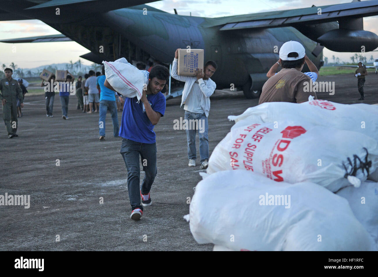 ORMOC, Republik der Philippinen - Mitglieder der bewaffneten Kräfte der Philippinen und Ormoc City Bewohner Offload Wasser, Reis und andere Hilfsgüter aus einem philippinischen Luftwaffe c-130 am Omloc Flughafen, am 16. November im Rahmen der Operation Damayan. Die Regierung der Philippinen koordiniert eng mit internationalen Hilfsaktionen zu den Bedürftigen zu helfen. (Foto: U.S. Air Force Captain Chris Hoyler) Philippinischen Streitkräfte führen Entlastung Bemühung in Ormoc (Bild 2 von 2) (10928070794) Stockfoto