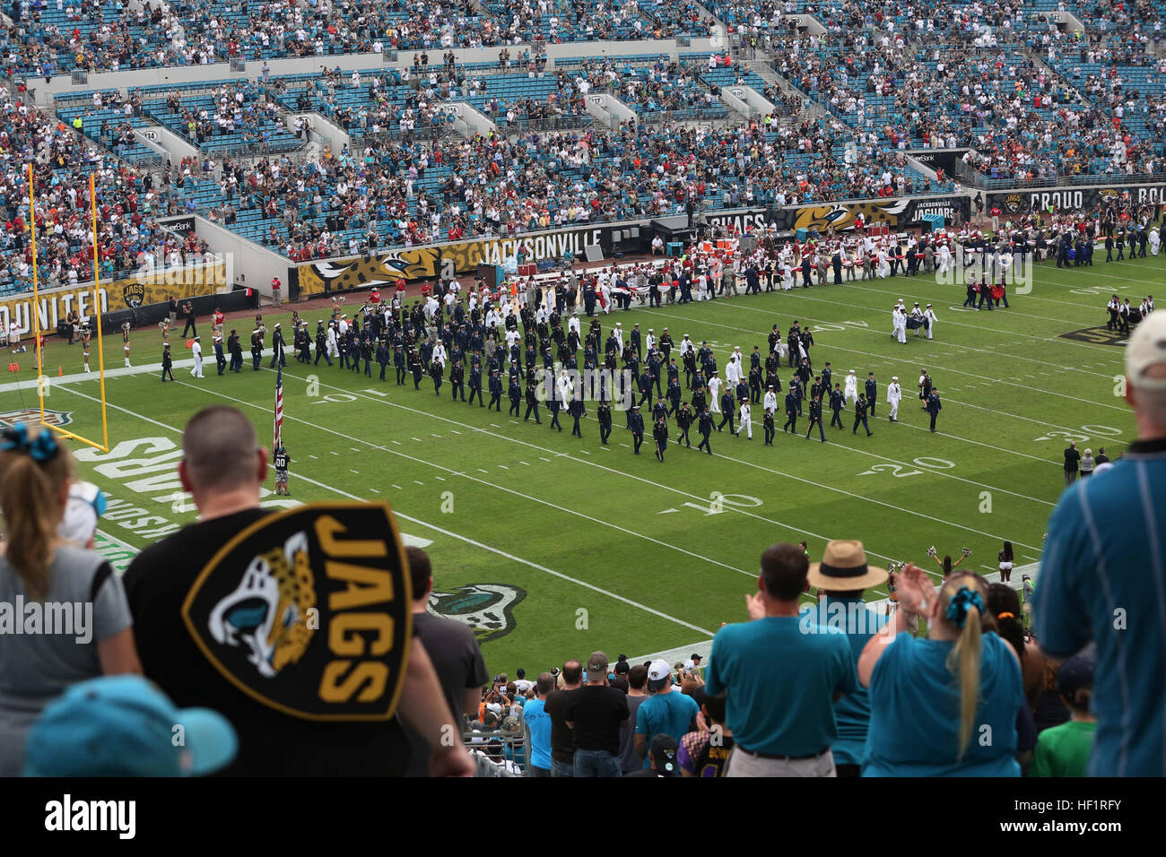 US-Militärangehörige darauf vorbereiten, eine amerikanische Flagge während des Singens der Nationalhymne bei der Pre-game Zeremonie in Jacksonville, Florida, 17. November 2013 anzeigen. US-Marines, Matrosen, Piloten und Soldaten nahmen an der Pre-game Zeremonie des Spiels Military Appreciation. (US Marine Corps Foto: LCpl. Alex W. Kouns, MCRD Parris Island Combat Kamera/veröffentlicht) Das Ritual des militärischen Wertschätzung 131117-M-GN053-186 Stockfoto