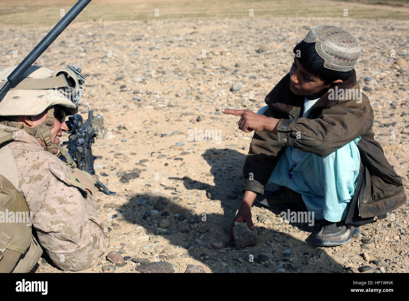 U.S. Marine Corps Lance Cpl Brian Wolfe, ein Schütze mit Charlie Kompanie, 1. Bataillon, 9. Marine Regiment, spricht zu einem lokalen afghanischen jungen während einer Patrouille in der Nähe von Patrol Base Boldak, Provinz Helmand, Afghanistan, 14. Januar 2014. Die Patrouille wurde durchgeführt, um feindliche Aktivitäten in der Umgebung stören. (Offizielle Marinekorps Foto von Lance CPL Zachery B. Martin/freigegeben) 1-9 Charlie Co. Patrouillen der Provinz Helmand 140114-M-WA264-006 Stockfoto