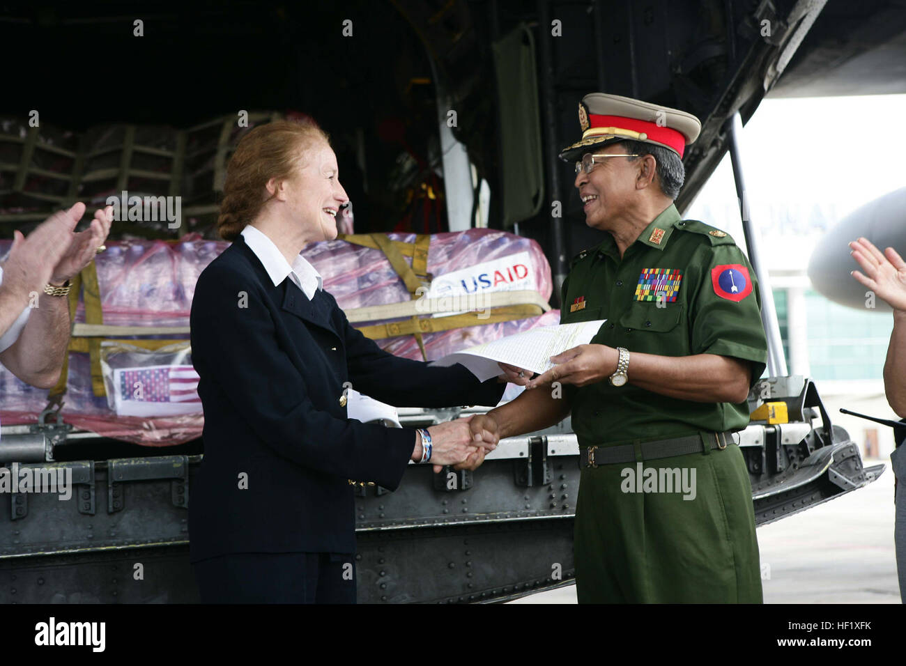 080512-M-8531A-097 RANGOON, Birma (12. Mai 2008) Henrietta H. Fore, grüßt Administrator für die U.S. Agency for International Development (USAID) einen burmesischen Beamten am Yangon International Airport während eine Luftbrücke von Hilfsgütern durch eine US Luftwaffe c-130 Hercules. Das Flugzeug mit Wasser, ist Nahrung und medizinische Versorgung Bestandteil der gemeinsamen Task Force Pflege Antwort und ein Multiservice humanitäre Hilfe Katastrophe Hilfsmaßnahmen für die birmanische Bürger durch Zyklon Nargis verwüstet. US Marine Corps Foto von Sgt. Andres Alcaraz (freigegeben) Wasser, Nahrung und Versorgungsmaterialien unterstützen Katastrophe Re Stockfoto