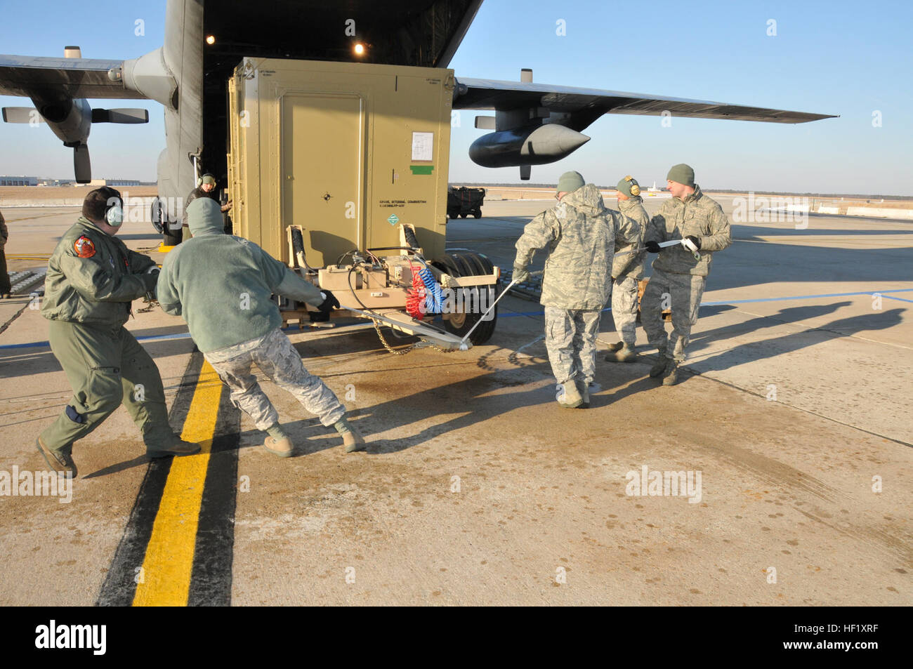 US Air Force Piloten aus der 182. Airlift Wing, Illinois Air National Guard und der 177. Kämpfer-Flügel, New Jersey Air National Guard Praxis Lenkung eine bereitgestellt Nachbesprechung Anlage auf einer C - 130H Hercules Transportflugzeuge in Atlantic City Air National Guard Base, N.J., 11. Februar 2014. Bei einem Gewicht von fast 13.000 Pfund, benötigt die DDF spezielle Rampen gebaut, um dazu beitragen, Bodenfreiheit und eine Seilwinde in das Flugzeug zu ziehen. (U.S. Air National Guard Foto von Master Sgt Andrew J. Moseley/freigegeben) Nationalgarde Teamleistung 140211-Z-YH452-172 Stockfoto