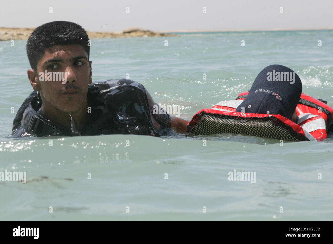 Ein irakischer Polizist zieht ein Klassenkamerad durch Wasser während einer Rettungsaktion schwimmen und Konditionierung Klasse im See Quadsiyah in Haditha, Irak, 9. Juli 2008. Irakische Polizisten aus um Al Anbar an Bootfahren Techniken teilnehmen und Wasser Überlebenskurs um wasserbasierende Operationen und Erhöhung der Sicherheit in der gesamten Al Anbars Wasserstraßen durchzuführen. (Foto: U.S. Marine Corps CPL. Seth Maggard/freigegeben) Ein irakischer Polizist zieht ein Klassenkamerad durch Wasser während einer Rettungsaktion schwimmen und Konditionierung Klasse im See Quadsiyah in Haditha, Irak, 9. Juli 2008 080709-M-QJ743-009 Stockfoto