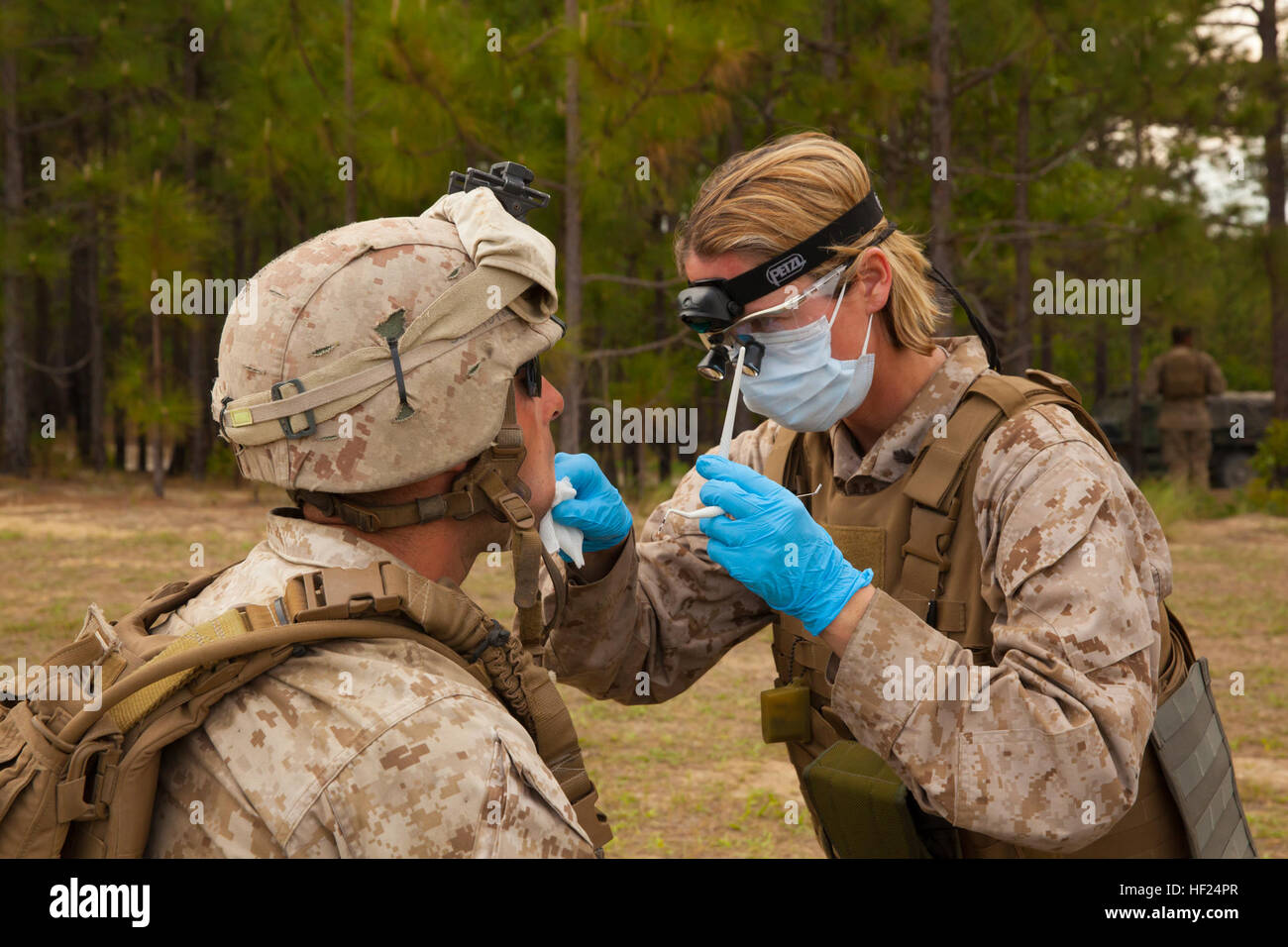 Navy Lt. Inga Keithly (rechts), gibt eine San Diego, Kalifornien, Native und Zahnarzt befestigt 2. Wartung Bataillon, Bekämpfung von Logistik-Regiment 25, 2. Marine Logistics Group, eine zahnärztliche Untersuchung eine Marine mit Golf Batterie, 10. Marine Regiment, 2. Marine-Division in der Nähe von der Schusslinie während Rolling Thunder, einer alle zwei Jahre stattfindende Übung auf Fort Bragg, N.C., 9. Mai 2014. Keithly entwickelt und ausgeführt einen Plan, um die Marines an der Front des Vorgangs, zahnärztliche Untersuchungen bringen wo die ständige Arbeit halten die Geschütze feuern Personal verhinderte die Zahnklinik für die exe-Datei einrichten Stockfoto