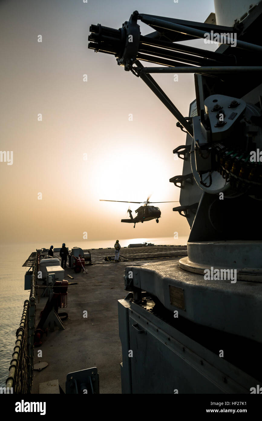 Eine Deck Hand auf die RFA Cardigan Bay, Royal Fleet Auxiliary, britische königliche Marine, gibt das Signal zum abheben, ein UH-60 medizinische Evakuierung Black Hawk von Piloten geflogen vom 1. Bataillon, 214th Air Ambulance, 42. Combat Aviation Brigade (CAB), US-Armee am 8. Juni 2014, irgendwo in den Persischen Golf.  Die Piloten ausgebildet auf Deck Landungen während Übung Spartan Kopis, einen Austausch zwischen der Cardigan Bay und die Black Hawk und AH-64 Apache Elemente der 42. Kabine, New York Army National Guard.    Spartan Kopis war das erste Mal amerikanischen Apachen mit einem Schiff der Royal Navy zu funktionieren als ich gearbeitet Stockfoto