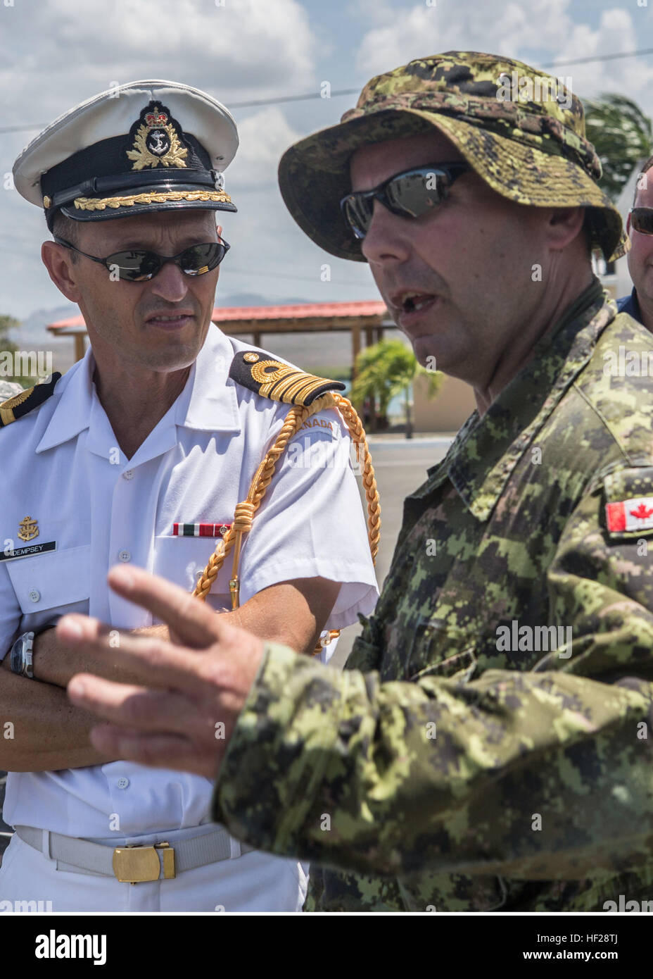 Captain Paul Dempsey, Canadian Defense Attaché für die Region spricht mit Warrant Officer Cecil Elliott, königliches kanadisches Regiment über die Fortbildungsveranstaltungen, die während des Trainings Tradewinds 2014 stattfinden, an Bord der Dominikanischen Naval Base, Las Calderas liegt in der Nähe von Bani, Dominikanische Republik, 23. Juni 2014. Capt Dempsey besuchte die Marinebasis und hatte die Gelegenheit, einige der Ausbildung Entwicklungen statt im Rahmen der Phase II der Übung zu beobachten. Phase II der Tradewinds 2014 ist meist eine Boden Feld Übung vom 16. Juni bis 25. Juni statt. Tradewinds 2014 ist eine gemeinsame Stockfoto