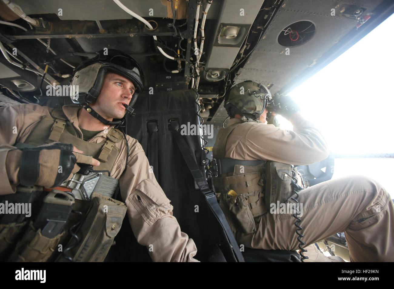 Achten Sie Staff Sgt Jonathan Lee, links, und Staff Sgt Kenneth Morris, beide Crew Chiefs mit Marine Light Attack Helicopter Squadron 467, auf verdächtige Aktivitäten auf dem Boden während einer Mission in der Provinz Helmand, Afghanistan, 3. Juli 2014. Marine Light Attack Helicopter Squadron 467 wurde an Bord der Marine Corps Air Station Cherry Point, North Carolina, vor fünf Jahren gegründet und ist auf ihren ersten Kampfeinsatz, als ein Geschwader. Die Marines HMLA-467 werden die letzten Marines nahe Luftunterstützung Operationen in Afghanistan zur Unterstützung der Operation Enduring Freedom durchzuführen. (US Marinecorps Foto: S Stockfoto