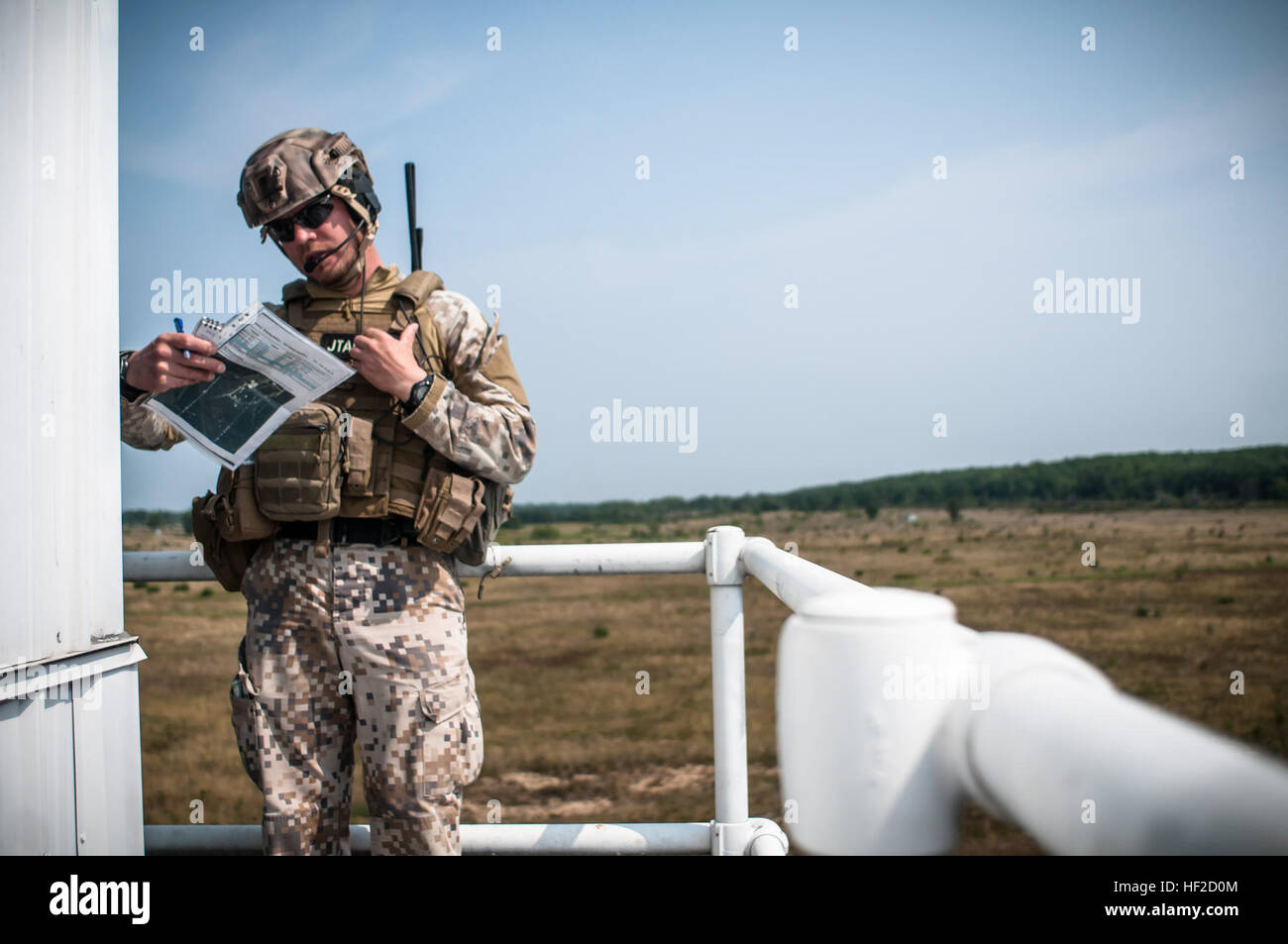 1st Sgt. Modris Circenis, eine gemeinsame Terminal Air Controller aus der lettischen Streitkräfte überprüft Kartenkoordinaten während im Gespräch mit einer c-130 Hercules aus der 182. Airlift Wing, Peoria, Illinois in Luft Drop Mission während der Operation Northern Strike 2014 in der Nähe von Äschen, Michigan am 8. August 2014. Operation Northern Strike 2014 ist eine gemeinsame multinationale kombinierte Waffen training Übung in Michigan durchgeführt. (U.S. Air National Guard Foto von Master Sergeant Scott Thompson/freigegeben) Operation Northern Strike 2014 140808-Z-GS745-092 Stockfoto