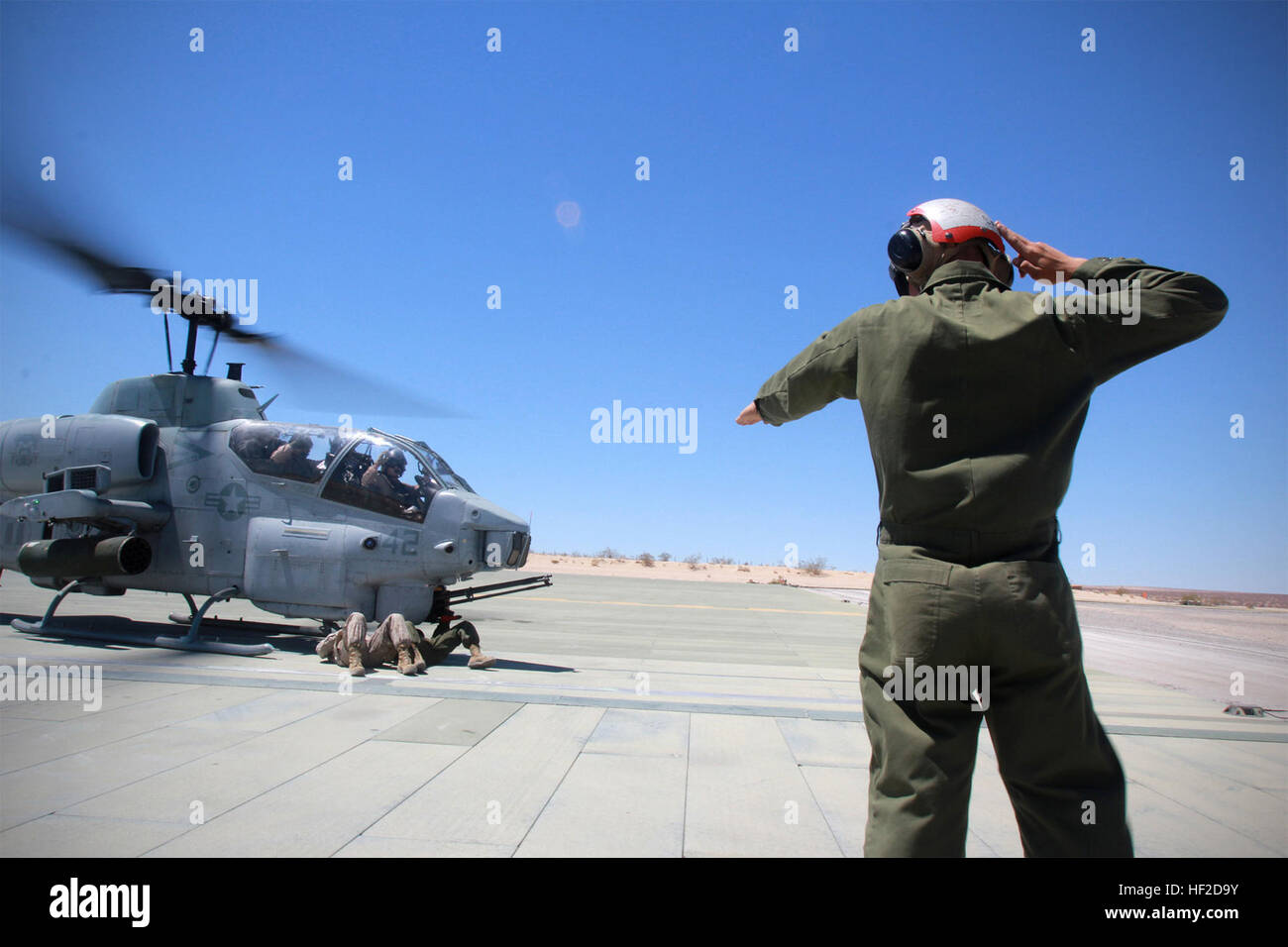 Verordnung Marines im Marine Corps Air Ground Combat Center Twentynine Palms kommunizieren mit Hand-Arm-Signale während der Scharfschaltung oder de-Bewaffnung der AH-1 Super Cobra Hubschrauber, wie der Motor und Rotor Lärm zu laut hörbare Befehle zu hören ist.  Ordie Teammitglieder arm M197 Gatling-Kanone und Piloten legen ihre Hände hoch über ihre Köpfe hinweg zeigen, dass sie nicht versehentlich irgendwelche Tasten während der Scharfschaltung Verfahren treffen. Ordies Arm Cobras an ITX 130613-M-IR064-011 Stockfoto