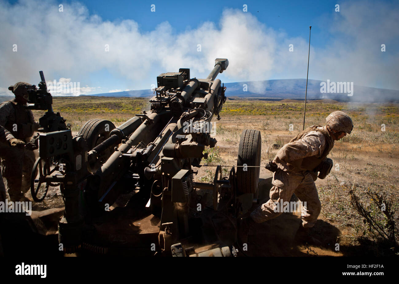 US Marine Sgt. Carlos Valles, ein Cannoneer zugewiesen, 1. Bataillon, 12. Marine Regiment, Alpha Batterie zieht die Landyard auf einer Haubitze M777 an Bord Pohakuloa Training Bereich (PTA), Hawaii, Sept. 2., 2014. Mitglieder des 1. Bataillons, 12. Marines (1/12), sind Steigerung ihrer Fähigkeiten des direkten Feuerunterstützung zur Unterstützung Betrieb spartanisch Zorn. (Foto: U.S. Marine Corps Lance Cpl. Victor A. Mancilla/freigegeben) Spartanisch Zorn 2014, 1-12 140902-M-AU949-001 Stockfoto