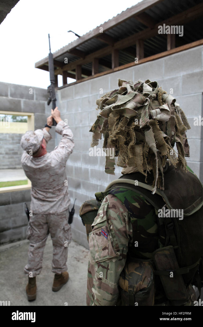 Eine Marine mit 2. Intelligence Battalion, II. Marine Expeditionary Force, zieht sich eine versteckte Waffe während des Trainings eine Suche mit britischen Soldaten aus 5, 6 und 7 Militärgeheimdienst Bataillone, 1 Intelligence Surveillance Reconnaissance Brigade, während Übung Phoenix Odyssey am 14. September 2014 durchgeführt. Die Tages-Training konzentriert auf taktische Seite Ausbeutung (TSE), wo die Marines und ihre britischen Kollegen ihre Techniken in Nachrichtenbeschaffung im Bereich geteilt. Die beiden Kräfte eine militärische Operationen in urbanem Gelände Schulungseinrichtung in Camp Lejeune für th Co befinden sich in Stockfoto