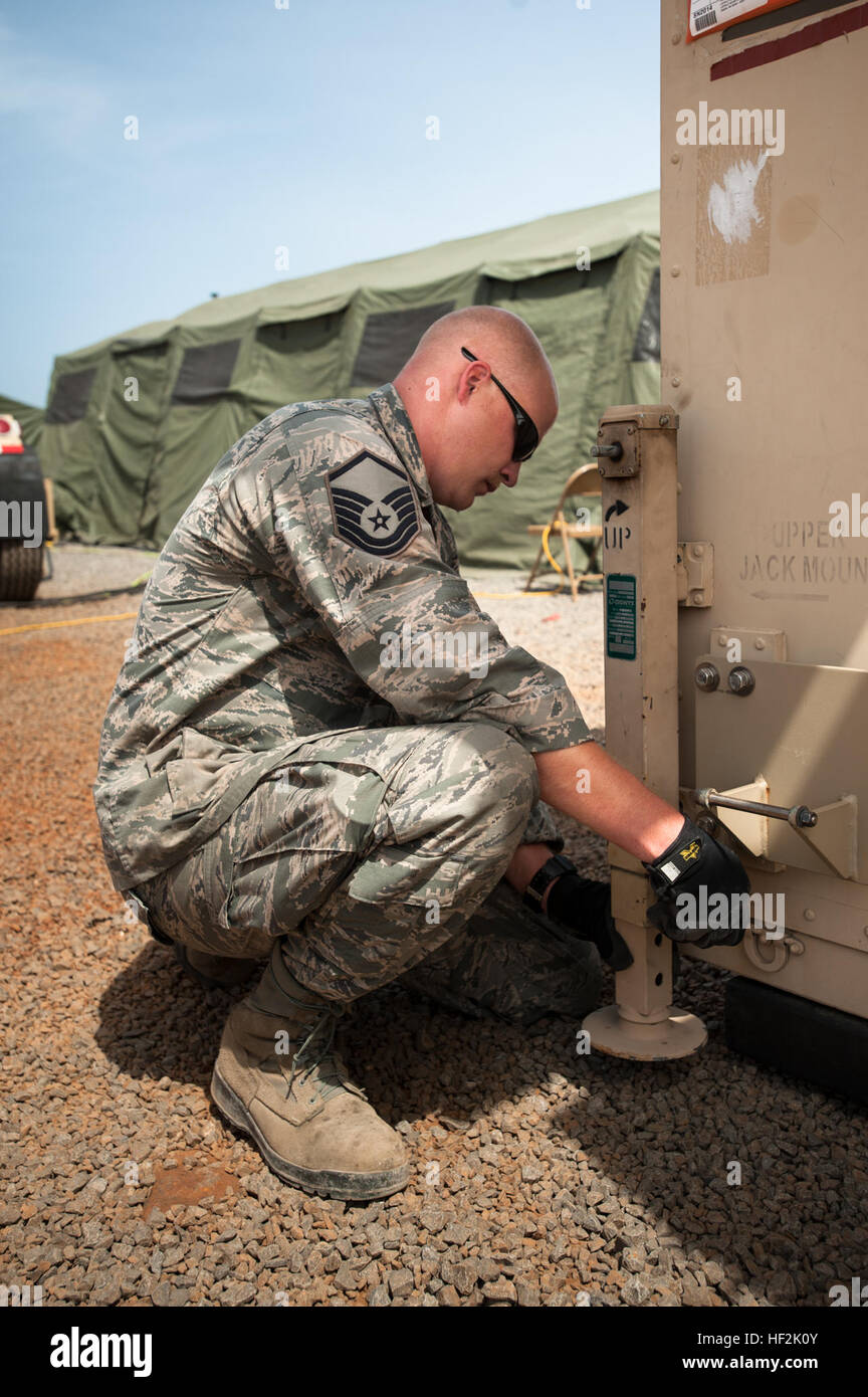 US Air Force Master Sergeant Matthew Hourigan der Kentucky Air National Guard 123. Kontingenz Reaktionsgruppe installiert Nivellierung Buchsen auf einem mobilen Flugplatz Operations Center bei Léopold Sédar Senghor International Airport in Dakar, Senegal, 17. Oktober 2014, für Betrieb United Unterstützung, der US Agency for International Development geführt, der gesamtstaatliche Anstrengung zur Beantwortung von Ebola-Ausbruch in Westafrika. Die Flieger sind ein Zwischenboden Inszenierung in Dakar um humanitäre Hilfe und militärische Unterstützungsausrüstung in den betroffenen Gebieten Trichter Betrieb arbeiten im Konzert mit s Stockfoto