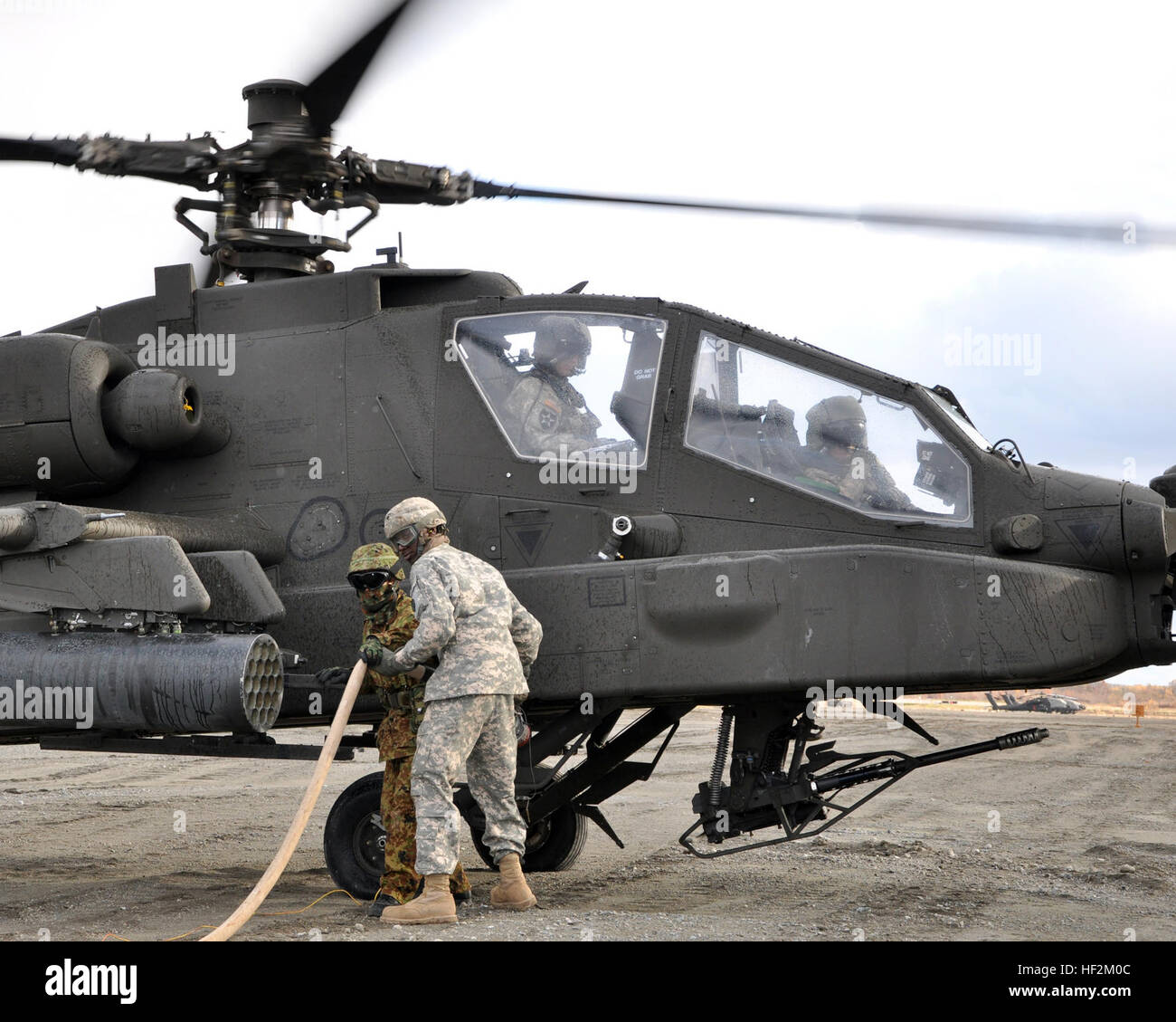 US Army Spc. Richard Mackey, ein auftankenden zugewiesen Firma E, 3. Bataillon, 25. Combat Aviation Regiment von Wheeler Field, Hawaii und Sgt. Yuta Kurita, eine Crew-Chief der JGSDF 7. Luftfahrt-Einheit aus Sapporo, Japan, zugeordnet tanken ein US AH-64 "Apache" Hubschrauber während Orient Shield 14 hier, Okt. 28. Die Luftfahrt-Refuelers unterstützen Soldaten aus dem 2. Stryker Brigade Combat Team, 2. Infanterie-Division von Joint Base Lewis-McChord, Washington, und JGSDF Mitglieder aus der 11. Infanterie-Regiment, 7. Division Nordarmee Bereich Training Übungen, 27 Okt. – 7. November. U.S. ein Stockfoto