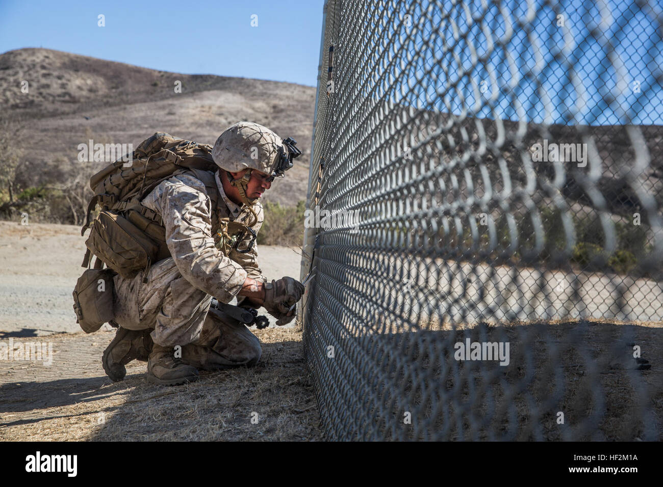 U.S. Marine CPL John Salazar Orte simulierten Sprengstoff um einen Zaun laufe eine vertikal-Angriff Razzia an Bord Camp Pendleton, Kalifornien, 29. Oktober 2014 zu verletzen. Salazar ist ein Ingenieur mit Lima, Battalion Landing Team 3. Bataillon, 1. Marineregiment, 15. Marine Expeditionary Unit. Der Kurs lehrt vertikalen Angriff Techniken und die Bedeutung der Zusammenarbeit als eine geschlossene Einheit während einer Razzia. (U.S. Marine Corps Foto von Sgt. Emmanuel Ramos/freigegeben) 3-1 Marines Verhalten vertikalen Angriff Ausbildung 141029-M-ST621-114 Stockfoto