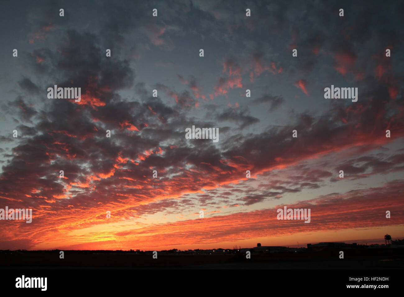 Ein Blick auf der südöstlichen Seite der Start-und Landebahn fünf und ein buntes Sonnenuntergang über dem Marine Corps Air Station Cherry Point, North Carolina, 18. November 2014.   Cherry Point ist die Heimat, 2. Marine Aircraft Wing und mehrere seiner Staffeln. Start-und Landebahnen Cherry Point betreiben 24/7, 365 Tage pro Jahr und die Luft Bahnhof Gastgeber-Staffeln, die spezialisiert auf Luft-Boden-Angriff zu unterstützen; elektronische Kriegsführung; Luftbild der Verkehrs- und tanken; und Meer und Land zu suchen und zu retten. Sonnenuntergang Gnaden Himmel über MCAS Cherry Point, Fischadler fliegt 141118-M-PJ332-109 Stockfoto