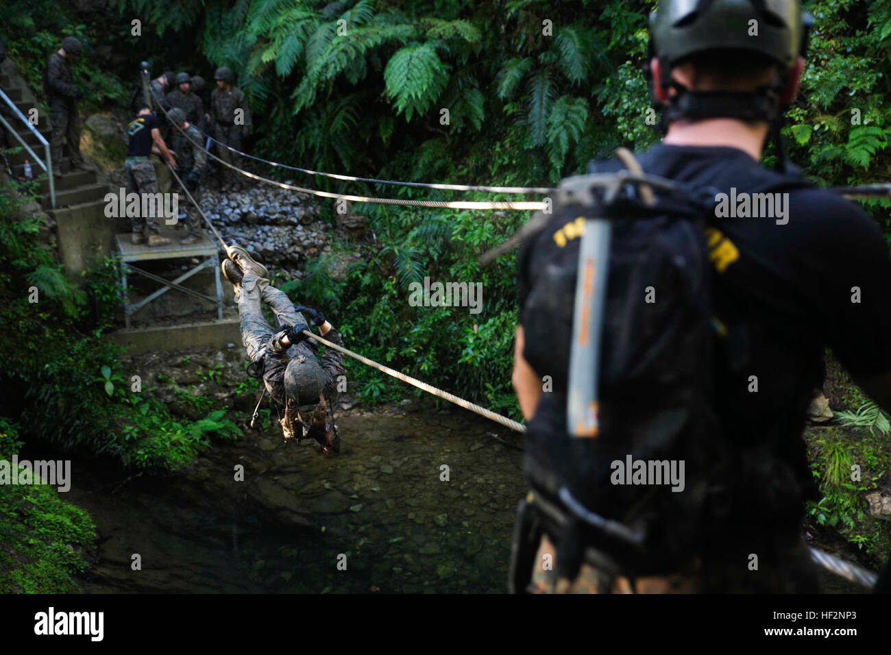 Lance Cpl. Jonathon E. Goff überquert einen Fluss Hindernis 25 November beim Durchlaufen der Jungle Warfare Training Center Ausdauer Kurs auf Lager Gonsalves. Der Ausdauer-Kurs ist ein 4-Meilen-Kurs mit Abseilen, Seilbrücken, Wasserhindernisse und eine simulierte Unfall Station beinhaltet. Goff ist ein Schütze mit 1. Bataillon, 1. Marineregiment, aktuell zugewiesene 4. Marine Regiment, 3. Marineabteilung, III. Marine Expeditionary Force, unter der Einheit-Deployment-Programm. (US Marine Corps Foto von CPL. Thor J. Larson/freigegeben) Marines laufen, Schwimmen, Abseilen durch OkinawaE28099s Berge 14112 Stockfoto