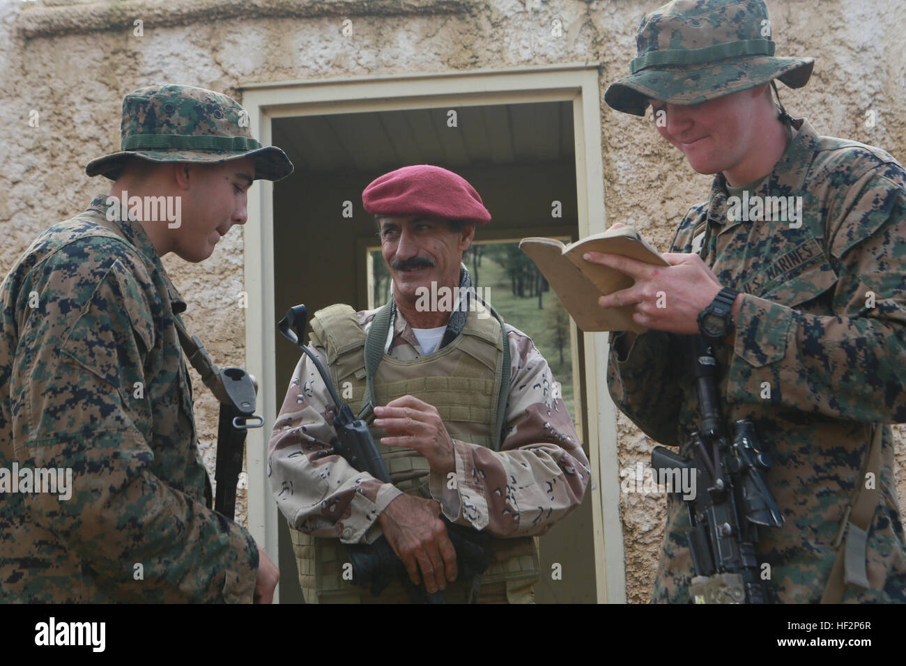 US-Marines lernen Arabisch von einer Role-player während einer realistischen städtischen Übung an Bord Fort Hunter Ligget, Calif., 6. Dezember 2014.  BRUNFT der 15. Marine Expeditionary Unit Marines auf ihren nächsten Einsatz vorbereitet, finden verbessern ihre Kampffähigkeiten in Umgebungen, die ähnlich wie diejenigen, die sie in zukünftigen Missionen. (US Marine Corps Foto von Sgt. Jamean Berry/freigegeben) Marines Verhalten bilaterale training 141206-M-GC438-095 Stockfoto