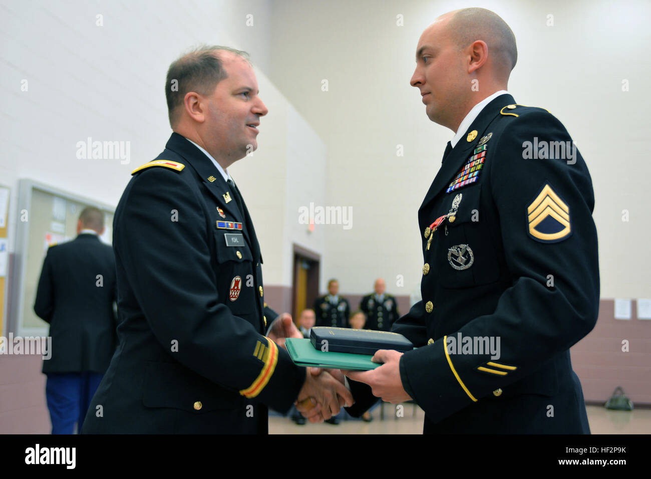 North Carolina National Guard Military Police Officer Armee Staff Sgt Andrew Braxton, Recht, 514. Militärpolizei DESUNTERNEHMENS ist geehrt, bei der Zeremonie im Captain Christopher Cash Armed Forces Reserve Center in Winterville, NC, 7. Dezember 2014, für Tapferkeit in Afghanistan während eines Angriffs auf 1. Oktober 2012, die drei NCNG Soldaten getötet und drei weitere verletzt.  Bullard erhielt den Bronze Star mit Tapferkeit Gerät. Kameraden, erhielt Sgt. Benjamin Bullard eine Army Commendation Medal mit Tapferkeit Gerät an der gleichen Zeremonie. "sie sind die Helden in unserer Mitte," sagte Armee Oberst Eric Kohl, links Stockfoto