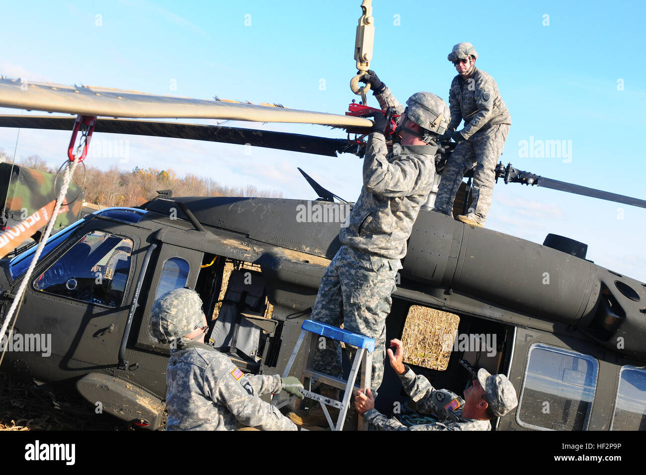 US-Soldaten aus der S.C. Army National Guard arbeiten um ein UH-60 Black Hawk von Ablösung 2, Unternehmen F, 1-171. General Support Aviation Battalion, South Carolina Army National Guard, Sling-Last Bewegung McEntire Joint National Guard Base, Eastover, S.C., 7. Dezember 2014 vorzubereiten. Der Black Hawk machte eine Notlandung auf offenem Feld 3. Dezember 2014, aufgrund einer Hauptrotor Klinge Störung in Columbia, SC Der Black Hawk wurde von den Unfall Review Board für Erholung und über Sling-Last unter einer S.C. Army National Guard CH-47 Chinook-Hubschrauber von Ablösung 1 transportiert wurde Stockfoto