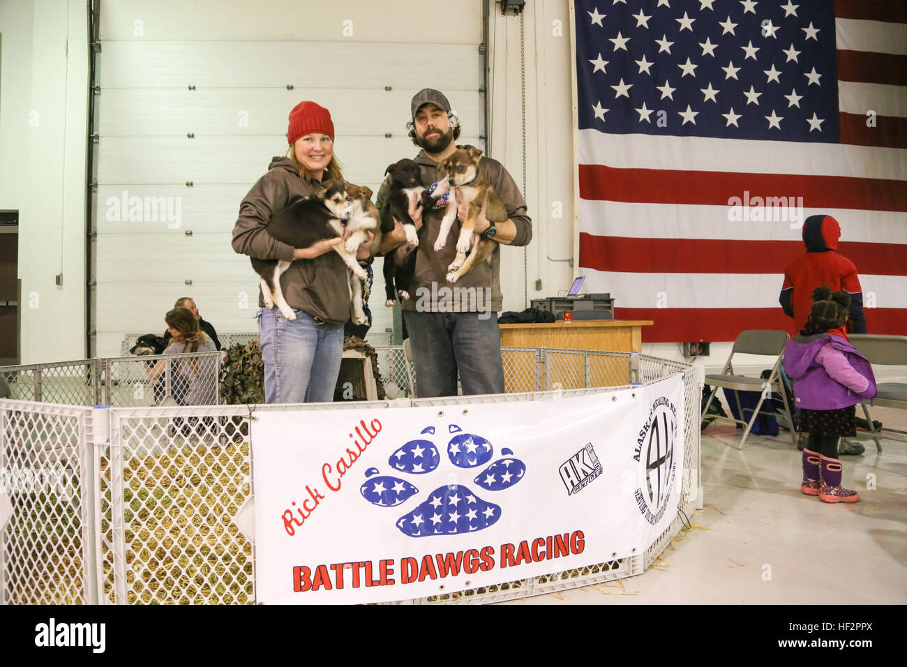 Schlacht Dawgs Racing Besitzer Generalmajor Jennifer Casillo, ein Flugzeug Wartung Offizier mit des 176. Flügels Wartung Geschwader und ihr Ehemann, Rick, fünf Mal Iditarod Musher, halten Sie ihre 8-Woche-alten Alaskan Huskies in Alaska National Guard Krieger und Familie Dienstleistungen Familie Weihnachtsparty auf der National Guard Armory auf gemeinsamer Basis Elmendorf-Richardson Dez. 13 statt. Die Casillos brachte in einem Wurf von Sled Dog Welpen für Familien auf der Party zu genießen. (US Army National Guard Foto von Sgt. Balinda O'Neal) Alaska Gardist Zwinger bietet Heilung zu kämpfen verwundet, müde 141213-Z-CA180-004 Stockfoto