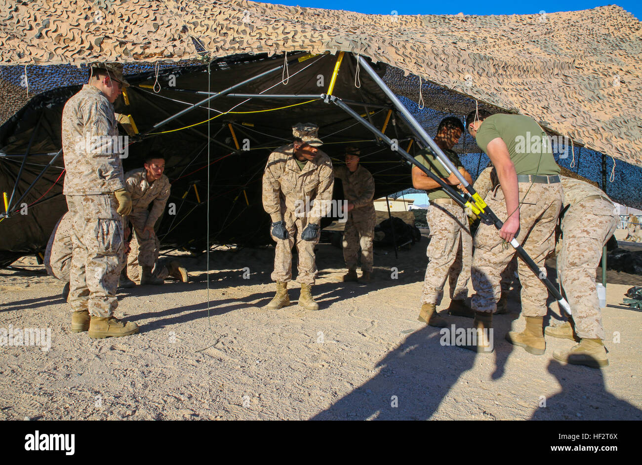 Marines richten Sie die Zelte für die Kampfhandlungen Zentrum für integrierte Übung 2-15 nach dem Einheben Camouflage netting-16. Jan. um Marine Air Ground Combat Center Twentynine Palms. Aufstellen der Saldierung zuerst, dann die Zelte macht Einrichtung viel einfacher, nach Staff Sgt Absalon A. Cabrera, Assistentin Operationen mit 4. Marine Regiment, 3. Marineabteilung, III. Marine Expeditionary Force und Lost Angeles, Kalifornien, native. Die Marines Arbeiten sind auch mit 4. Marines. (Foto: U.S. Marine Corps Lance Cpl. William Hester / veröffentlicht) Combat Operations Center startet ITX Stockfoto