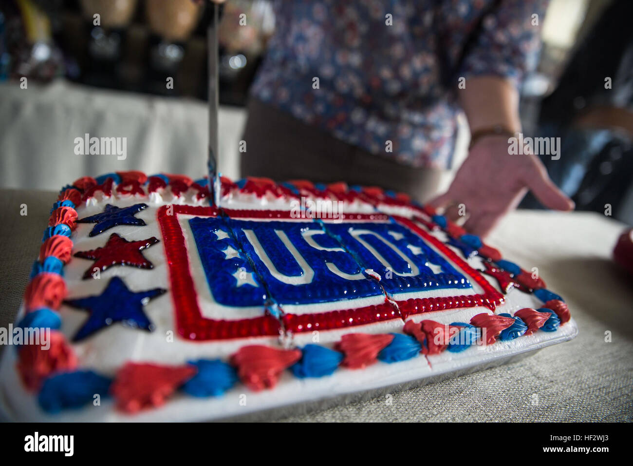 Ein Bediensteter schneidet einen Kuchen 2. Februar anlässlich der USO 74. Geburtstag in Verbindung mit einem 2015 Super Bowl Party in Camp Foster USO. Die Feier beinhaltete eine live-Übertragung des Fußballspiels auf mehreren TV-Bildschirmen gespielt wird, während Soldat innen gegrillter Käse Sandwiches und Würstchen serviert wurden. Die USO war 4. Februar 1941 gegründet, um Moral, Wellness und Erholung, kriegsmüden Truppen, einschließlich Ferienpartys und Geschenk-Pakete ins Ausland zu schicken. (US Marine Corps Foto von Sgt Henry J. Antenor/freigegeben) USO feiert 74. Geburtstag mit 2015 Super Bowl Party 150202-M-FX6 Stockfoto