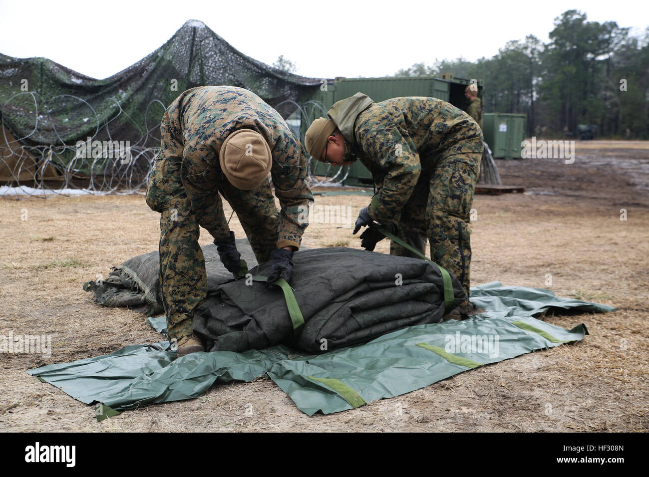 Sergeant Ezequiel M. Herrada (links), Versorgung, administrativer Leiter für zentrale Regiment und CPL gewann Gyu Lee (rechts), liefern Administrator für zentrale Regiment, Pack Camouflage netting während einer Stabsrahmenübung an Bord der Marine Corps Base Camp Lejeune, North Carolina, 25. Februar 2015. Die CPX zielte, die Einheit Bereitschaft zu gewährleisten und Bereiche verbesserungsbedürftig. (US Marine Corps Foto von Chelsea D. Toombs/freigegeben) 2. Marine Logistics Group erträgt Kälte während CPX 150225-M-LO802-008 Stockfoto