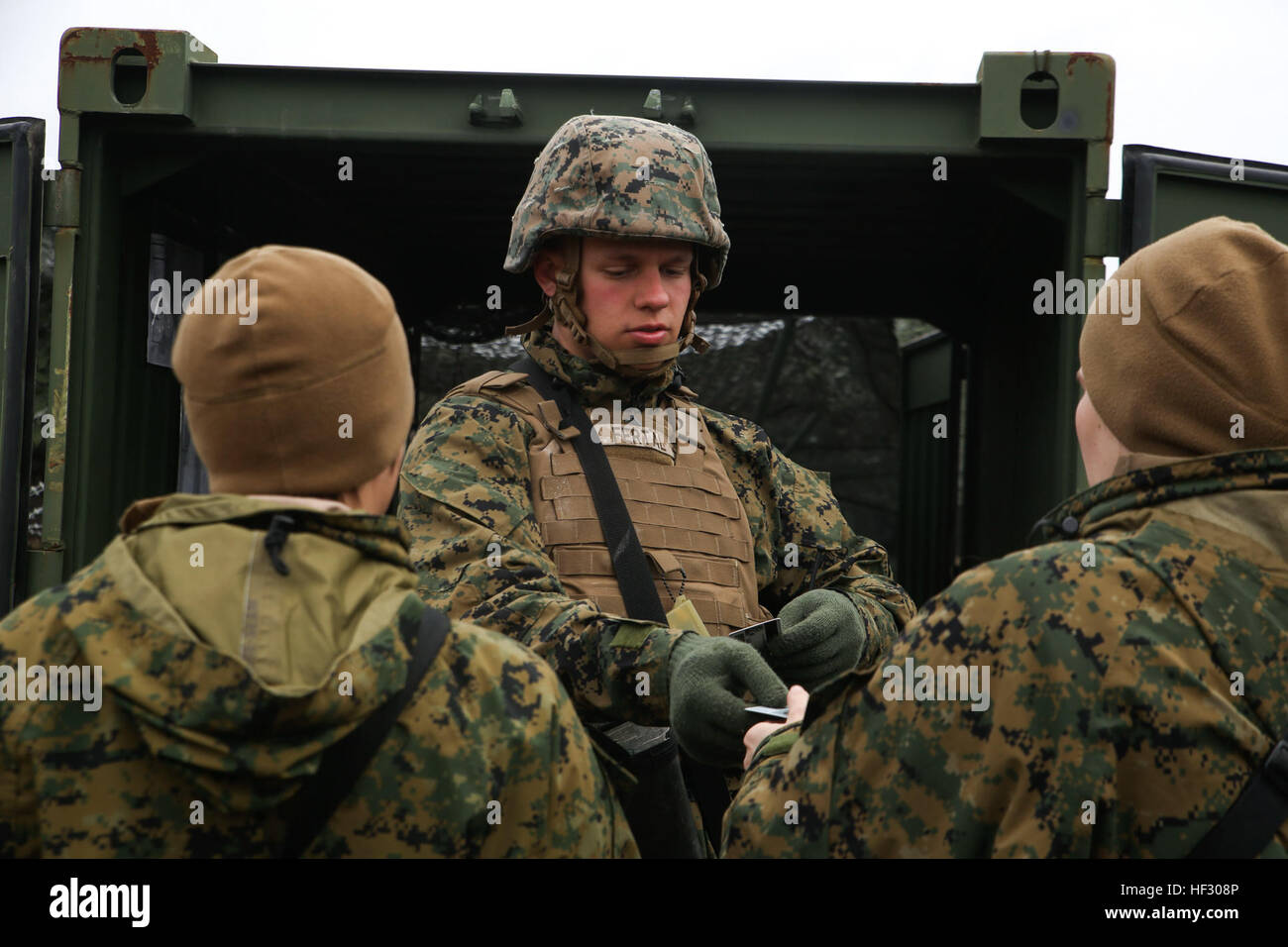 Ein Mitglied der Wache Kraft für den 2. Marine Logistics Group Stabsrahmenübung sorgt für die Gültigkeit der Personen, die in der Kommandozentrale Operationen durch Identifikation Karten während der CPX an Bord der Marine Corps Base Camp Lejeune, North Carolina, 25. Februar 2015 überprüfen. Die Wache Kraft soll garantieren, dass niemand die Kommandozentrale Operationen eigenmächtig oder Escort durchläuft. (US Marine Corps Foto von CPL. Chelsea D. Toombs/freigegeben) 2. Marine Logistics Group erträgt Kälte während CPX 150225-M-LO802-026 Stockfoto