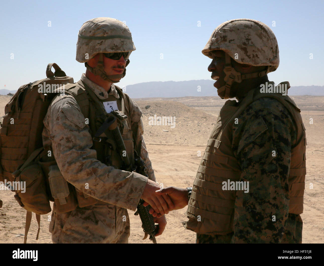 CPL. Joshua J. Syverson, Kampfingenieur mit Engineer Platoon, Sitz und Dienstleistungsunternehmen, Ground Combat Element integrierte Task Force, schüttelt Hände mit Sgt. Major Ronald L. Green, Sergeant Major of the Marine Corps während seines Besuchs in Reihe 107 in Marine Corps Air Ground Combat Center Twentynine Palms, Kalifornien, 7. März 2015. Ab Oktober 2014 bis Juli 2015, führen die GCEITF individuelle und kollektive Ebene Qualifizierungsmaßnahmen bezeichnet Boden combat Arms berufliche Spezialitäten erleichtern die Standards basierende Beurteilung der körperlichen Leistungsfähigkeit der Marines in einem Stockfoto