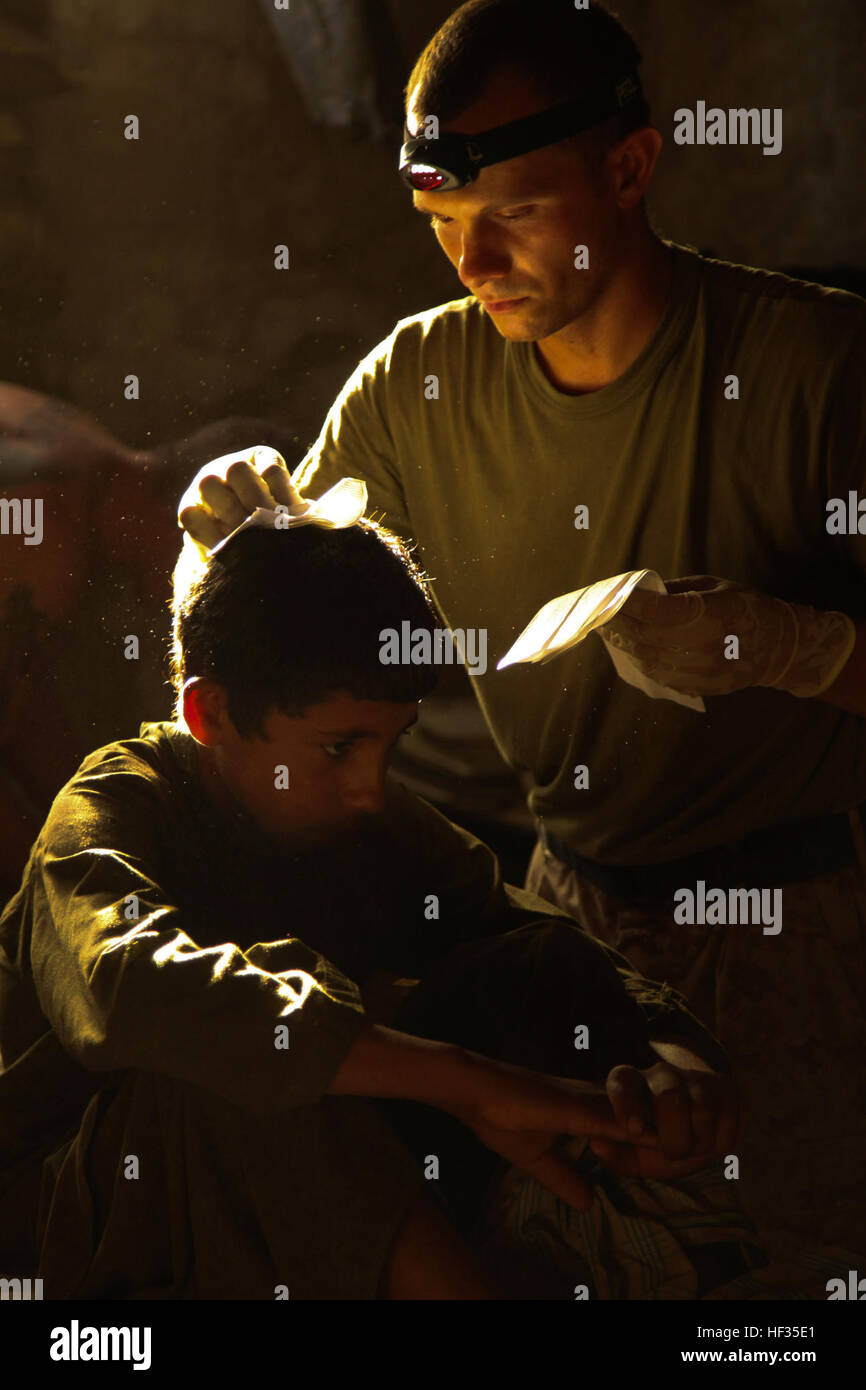 090715-M-2581P-888 Provinz HELMAND, Afghanistan (15. Juli 2009) Hospital Corpsman 2. Klasse Brian Saudau, von Mitchell, South Dakota, 1. Bataillon, 5. Marineregiment zugewiesen behandelt einen lokalen afghanischen jungen für eine Platzwunde an den Kopf bei Patrol Base Jaker in der Nawa Bezirk der Provinz Helmand in Afghanistan. (U.S. Marine Corps Foto Foto: Lance Cpl. James B. Purschwitz/freigegeben) US Navy 090715-M-2581 P-888 Hospital Corpsman 2. Klasse Brian Saudau, von Mitchell, South Dakota, 1. Bataillon, 5. Marineregiment zugewiesen behandelt einen lokalen afghanischen jungen für eine Platzwunde an den Kopf Stockfoto