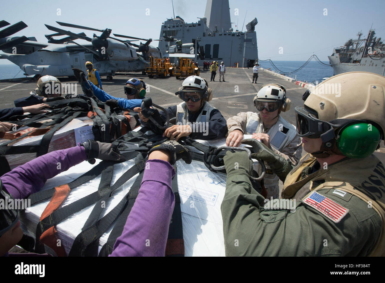 Marines mit dem 24. Marine Expeditionary Unit und Segler mit der Iwo Jima amphibisches bereit Gruppe entpacken eine Palette von Lieferungen während einer vertikalen Nachschub auf See an Bord der amphibischen Transportschiff der Dock USS New York (LPD-21), 24. April 2015. Die 24. MEU ist auf den Schiffen des Iwo Jima ARG begonnen und wird bereitgestellt, um die Aufrechterhaltung der Sicherheit in den USA 5. Flotte Einsatzgebiet. (Foto: U.S. Marine Corps CPL. Todd F. Michalek/freigegeben) 24. MEU, vertikale Nachschub am Meer 150424-M-YH418-002 Stockfoto