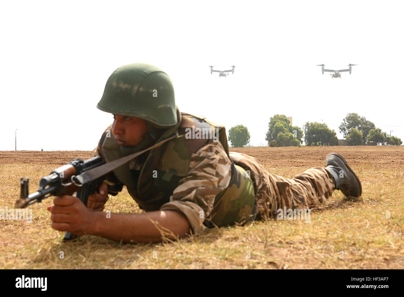 Ein marokkanische Soldaten bietet Sicherheit, ein Abschnitt der MV-22 Fischadler Vorbereitung zu landen und eine Kontingent von Marines als Verstärkung 20 Mai in Tifnit, Marokko Trainingsbereich einfügen. Ein Kipp-Rotor-Einschub mit Sicherheit gehörte zu mehreren Demonstrationen für allgemeine Offiziere aus den teilnehmenden Ländern. DV-Tag wurde so konzipiert, Beobachtung der was während des einwöchigen Trainings im Camp als Teil der Übung African Lion 2015 erreicht worden war. Übung afrikanischen Löwen 15 übt sich jährlich geplant, kombinierte U.S.–Moroccan zur Verbesserung des gegenseitigen Verständnisses einer jeden nation Stockfoto