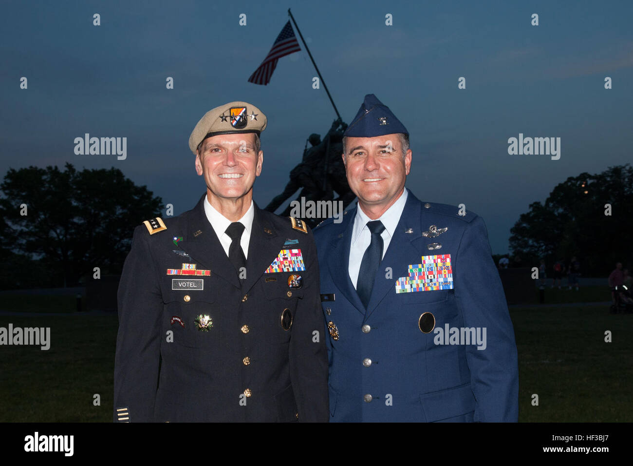 US-Armee General Joseph L. Votel, Commander, US Special Forces Command, links, posiert für ein Foto mit einem Gast beim Abschluss der Sonnenuntergang Parade auf der Marine Corps War Memorial in Arlington, VA., 26. Mai 2015. Seit September 1956 haben marschierende und musikalische Einheiten von Marine Barracks Washington, D.C., in Würdigung wurde für diejenigen, die "ungewöhnlich Tapferkeit war eine gemeinsame Tugend" durch die Vorlage Sonnenuntergang Paraden im Schatten der 32-Fuß hohe Persönlichkeiten des United States Marine Corps War Memorial. (U.S. Marine Corps Foto von Lance Cpl. Alejandro Sierras/freigegeben) Sonnenuntergang-Parade 150526-M-GK605-434 Stockfoto