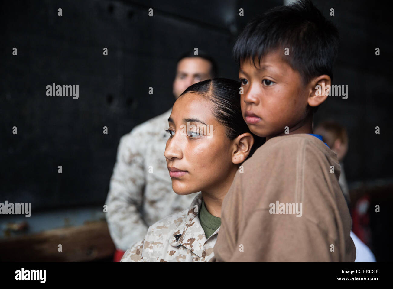 U.S. Marine Lance CPL Karina Navarro-Aguilera trägt ein Indonesien Kind, wie er darauf wartet, von der USS Rushmore (LSD-47), 11. Juni 2015, eine indonesische Küstenwache Schiff transportiert werden. Navarro-Aguilera ist Sachbearbeiterin Versorgung mit Bekämpfung der Logistik-Bataillon 15, 15. Marine Expeditionary Unit. Das Kind zusammen mit 64 anderen notleidenden Seeleute gerettet wurde aus einem sinkenden Handwerk in der Makassar-Straße zwischen den indonesischen Inseln Kalimantan und Sulawesi. Einmal an Bord, die Mariners Essen und ärztliche Hilfe Marines und Matrosen der 15. MEU und Essex amphibische Re erbrachten Stockfoto