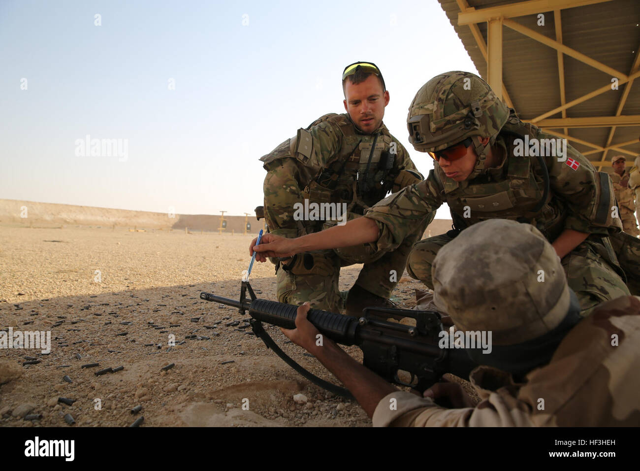 Dänische Koalitionsmitglieder mit Task Force Al Asad besprechen das Visier eines M16 Gewehr während Treffsicherheit Training auf Al Asad Air Base, Irak, 27. Juli 2015. Durch die Beratung und Unterstützung und Gebäude Partner Kapazität Missionen, Combined Joint Task Force-Betrieb verbundenen lösen multinationale Koalition hat ca. 11.000 irakische Sicherheitskräfte zu besiegen, der islamische Staat im Irak und der Levante und Wiederherstellung der Souveränität und Sicherheit des Irak ausgebildet. (Foto: U.S. Marine Corps CPL Jonathan Boynes/freigegeben) Koalition Sicherheitskräften Züge irakischen, ISIL 150727-M-PS zu besiegen Stockfoto