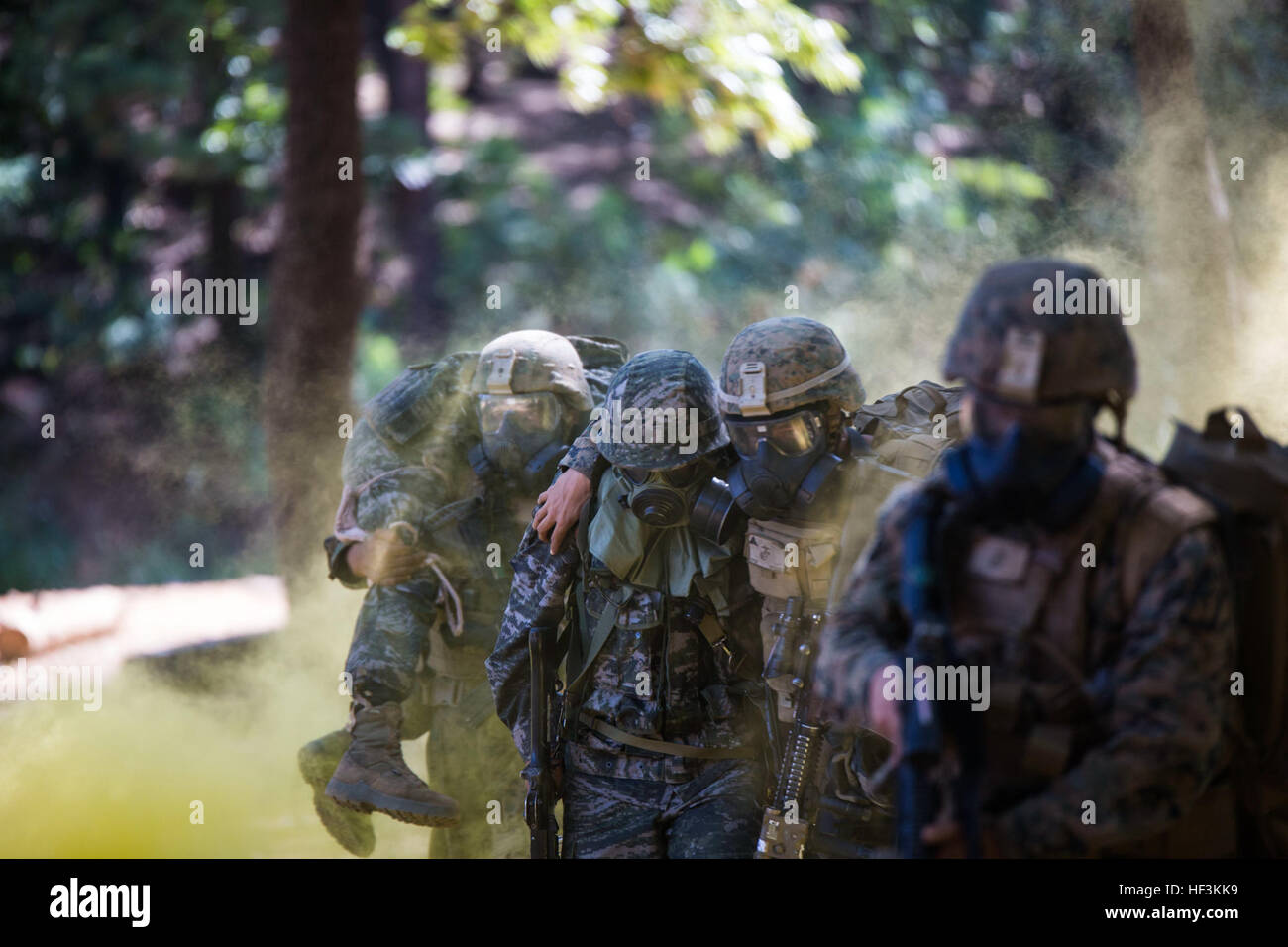 Republik der Korea Marine Lance Cpl. Jun Shin, Center, ein US-Marine-Umzug nach Sicherheit während einer Gas-Angriff-Drill als Teil der koreanischen Marine Austauschprogramm 15-12 bei Gunha-Rhi, Republik Korea, 17. September 2015 unterstützt. Der Bohrer war Teil des KMEP 15-12, eine Übung, die die Republik Korea und den USA Allianz, fördert die Stabilität auf der koreanischen Halbinsel und stärkt die Republik Korea und den USA militärische Fähigkeiten und Interoperabilität. Shin ist mit 11. Bataillon, 1. Regiment, 2. Marine-Division, 2. Kompanie, ROK Sitz Marine Corps. Die US-Marines sind mit Fox Company, 2. Bataillon, 3. Marine-Therapie Stockfoto