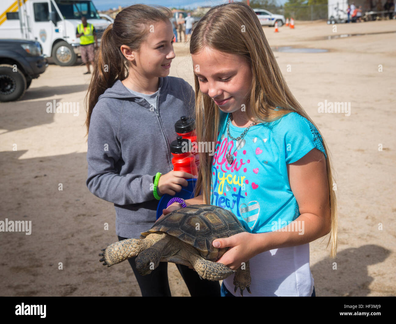 Sabryna Gromley, 11, Student in Twentynine Palms Elementrery, Tochter des Staff Sgt Michael Pugliese, Luftfahrt-Operationen-Experte, Marine Wing Support Squadron 374, hält Louise, Wüste Schildkröte, natürliche Ressourcen und Umwelt Abteilung, während die Stadt Twentynine Palms Gruß an diejenigen dienen, die Feier in der Twentynine Palms Junior High School Tom Nicoll Memorial Stadium, 16. Oktober 2015. (Offizielle Marinekorps Foto von Lance Cpl. Levi Schultz/freigegeben) Combat Center verbindet Salute 151016-M-PS017-063 Stockfoto