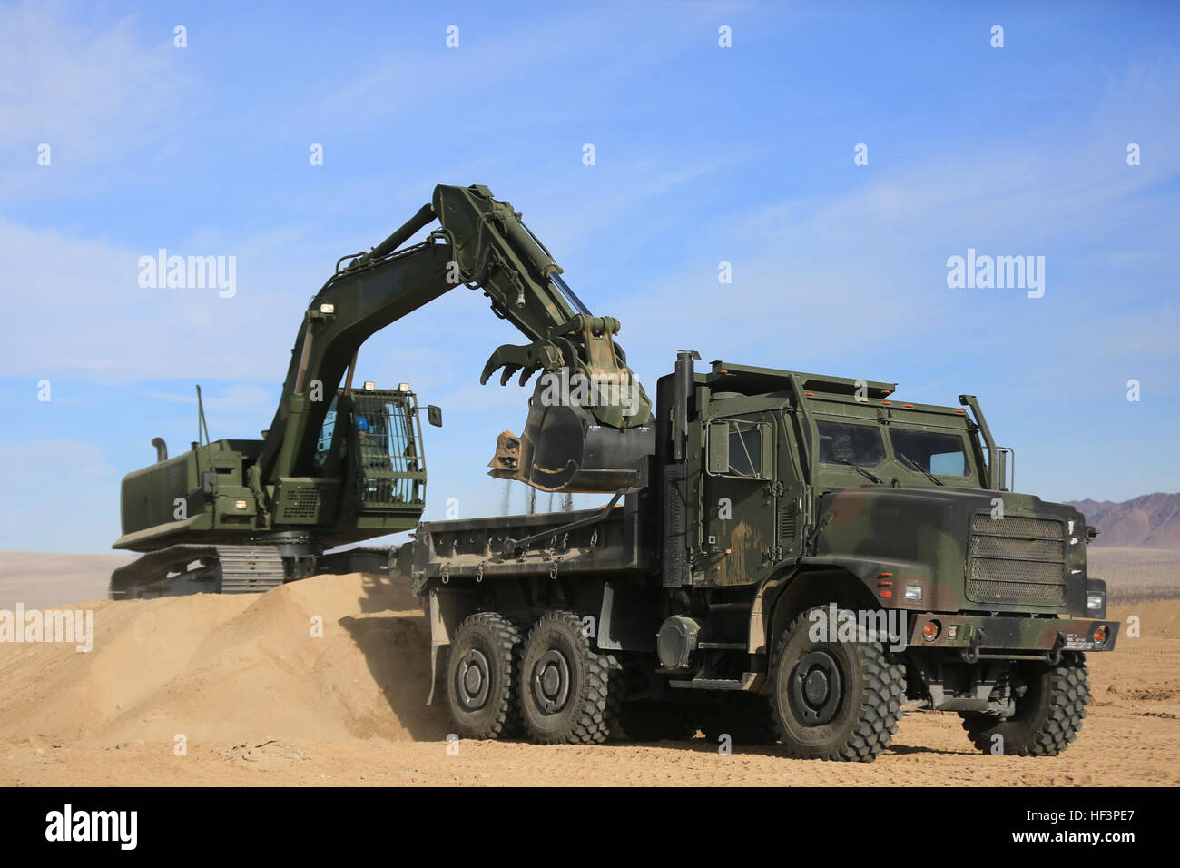 Staff Sgt John Vasquez, schweres Gerät Operationen Chef, Marine Wing Support Squadron 374, schöpft Sand ins Medium Tactical Vehicle Ersatz mit einem John Deere 250 GR Hydraulikbagger in der Nähe von strategischen Expeditionary Landeplatz, 22. Januar 2016. Dies ist das erste Mal Hap-374 dieser Bagger an Bord der Combat Center verwendet wird, und es ist in der Lage, der Verwendung von austauschbaren Anhänge, um kritische engineering Missionen zu erfüllen. (Offizielle Marinekorps Foto von CPL. Julio McGraw/freigegeben) "Nashörner" Feld neue Hydraulikbagger 160123-M-FZ867-603 Stockfoto