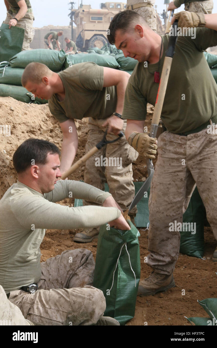 Marines graben Gruben, die als ihren Lebensraum dienen werden, und füllen Sandsäcke um sie, am Beobachtungsposten Huskars in der Provinz Helmand, 14. Januar 2010 zu stärken. Die Marines und Segler von Alpha und Waffen Unternehmen, 1. Bataillon, 6. Marineregiment und Anhänge aus 2. Combat Engineer Battalion, umgezogen tiefer in der Provinz Helmand um den Talibans Kontrolle über das Gebiet zu begrenzen, indem er eine prominentere Koalition Präsenz in der Region zu zwingen. Stiefel auf dem Boden aufschlug mit Schaufeln in der hand; Marines kommen, stärken Beobachtungsposten Huskars DVIDS240690 Stockfoto
