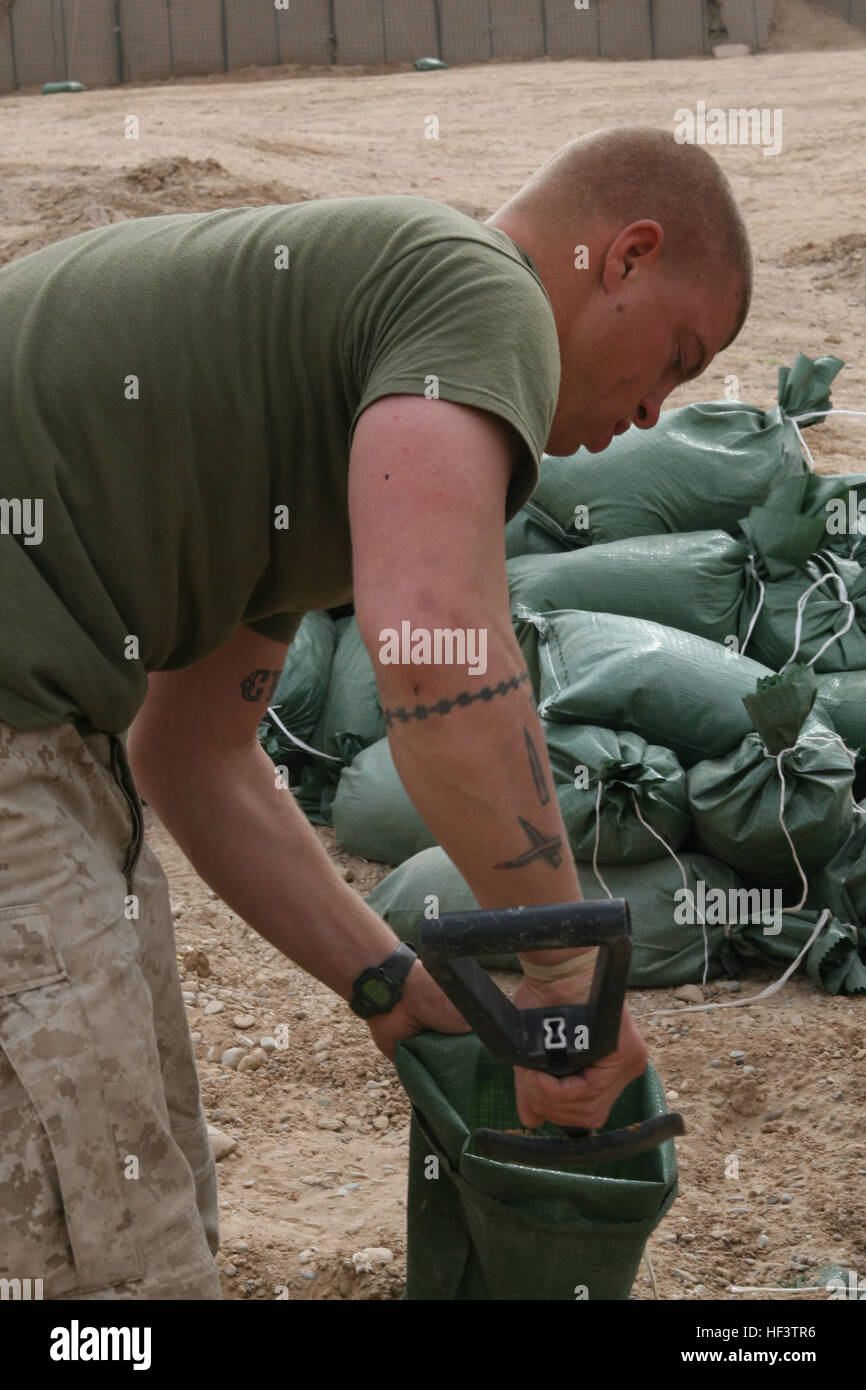 Lance CPL Henry D. Kornegay aus North Carolina und eine Real-Kader automatische Waffe Kanonier mit Alpha Company, 1. Bataillon, 6. Marineregiments füllt Sandsäcke auf Beobachtungsposten Huskars in der Provinz Helmand, 14. Januar 2010. Die Marines und Segler von Alpha und Waffen Co., 1/6 und Anlagen aus 2. Combat Engineer Battalion, umgezogen tiefer in der Provinz Helmand um den Talibans Kontrolle über das Gebiet zu begrenzen, indem er eine prominentere Koalition Präsenz in der Region zu zwingen. Stiefel auf dem Boden aufschlug mit Schaufeln in der hand; Marines kommen, stärken Beobachtungsposten Huskars DVIDS240691 Stockfoto