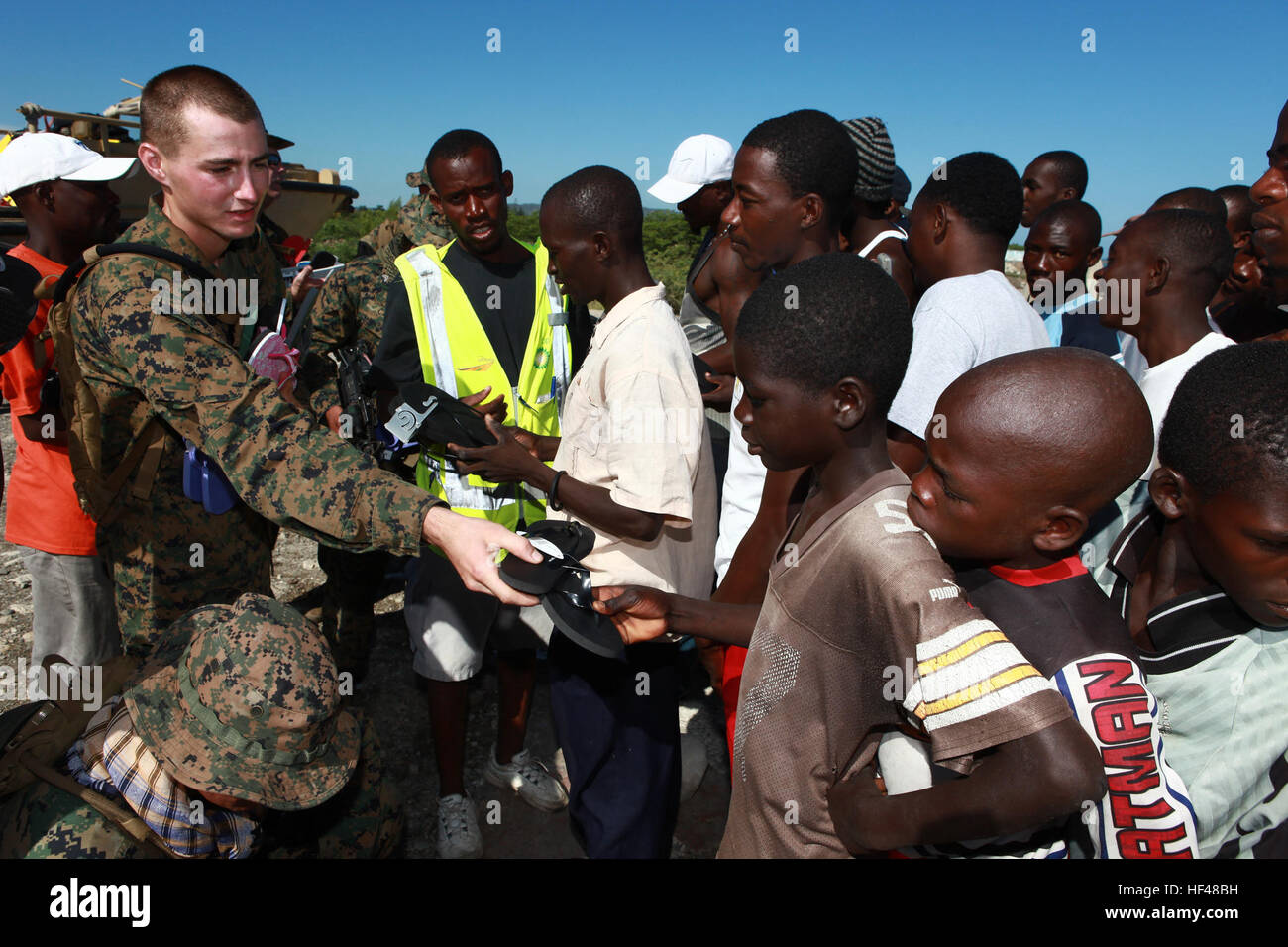 US Marine CPL David Shields, befestigt, Spezial-Marine Air-Ground Task Force anhaltende Versprechen 2010 verleiht Sandalen haitianische Kinder bei Kontrolle einen Einstiegspunkt in einer Verbindung in Port-de-Paix, Haiti, der Vereinten Nationen 27 Juli. CP10 ist eine kooperative Bemühung, die militärische und zivile Personal für humanitäre Hilfe und Katastrophenschutz, Karibik, Mittel- und Südamerika umfasst. Betrieb weiterhin Versprechen 2010 DVIDS307304 Stockfoto