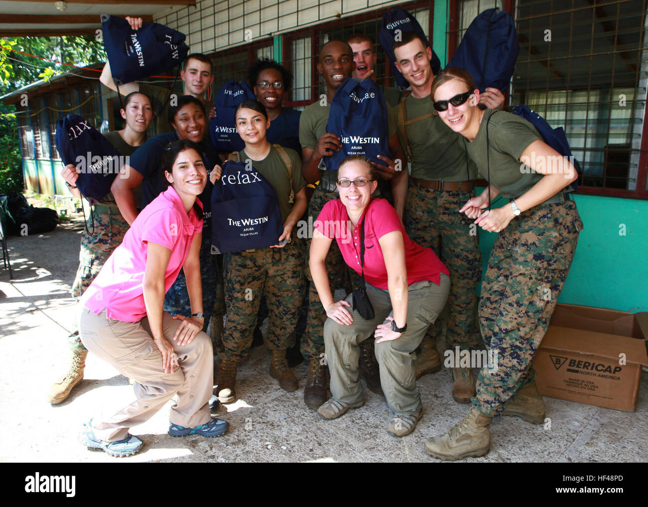 Unten links und rechts, Janina Viteri und Kari Williams mit der Gruppe der nicht-Regierungs-Organisation geben ein Kind einen Rucksack; posieren für ein Foto mit US-Marines und Matrosen an Betrieb weiterhin Versprechen 2010, während der Präsentation von Studenten mit Rucksäcken, Schulbedarf, Hone Creek Schule in Hone Creek, Costa Rica, Aug. 25 enthält. US-Militärangehörige und Zivilisten sind zur Unterstützung CP10, Einsatz für humanitäre Hilfe und Katastrophenschutz, Karibik, Mittel- und Südamerika. Betrieb weiterhin Versprechen 2010 DVIDS312970 Stockfoto