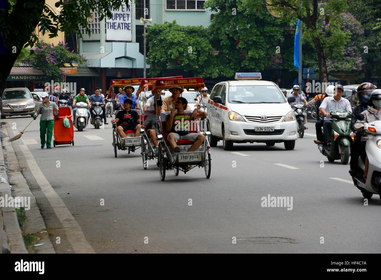 Hanoi Road. Autos und Rikscha fahren durch Straße. Nord-Vietnam, Hanoi. 3. Mai 2013 Stockfoto