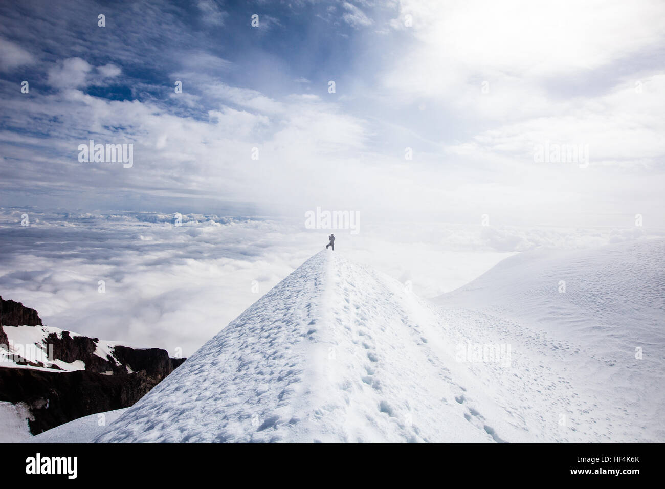 Ein junger Mann mit dem Fotografieren der umliegenden Berge vom Gipfel des Glacier Peak, Washington State Stockfoto