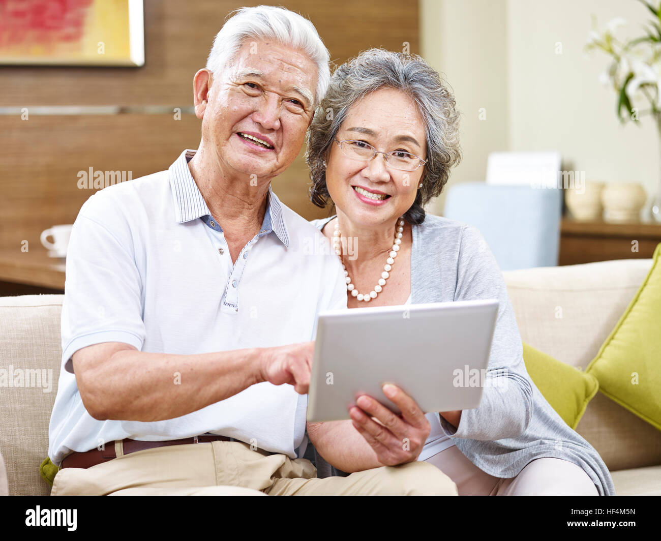 asiatische senior Brautpaar mit Tablet PC Blick auf die Kamera zu Lächeln. Stockfoto