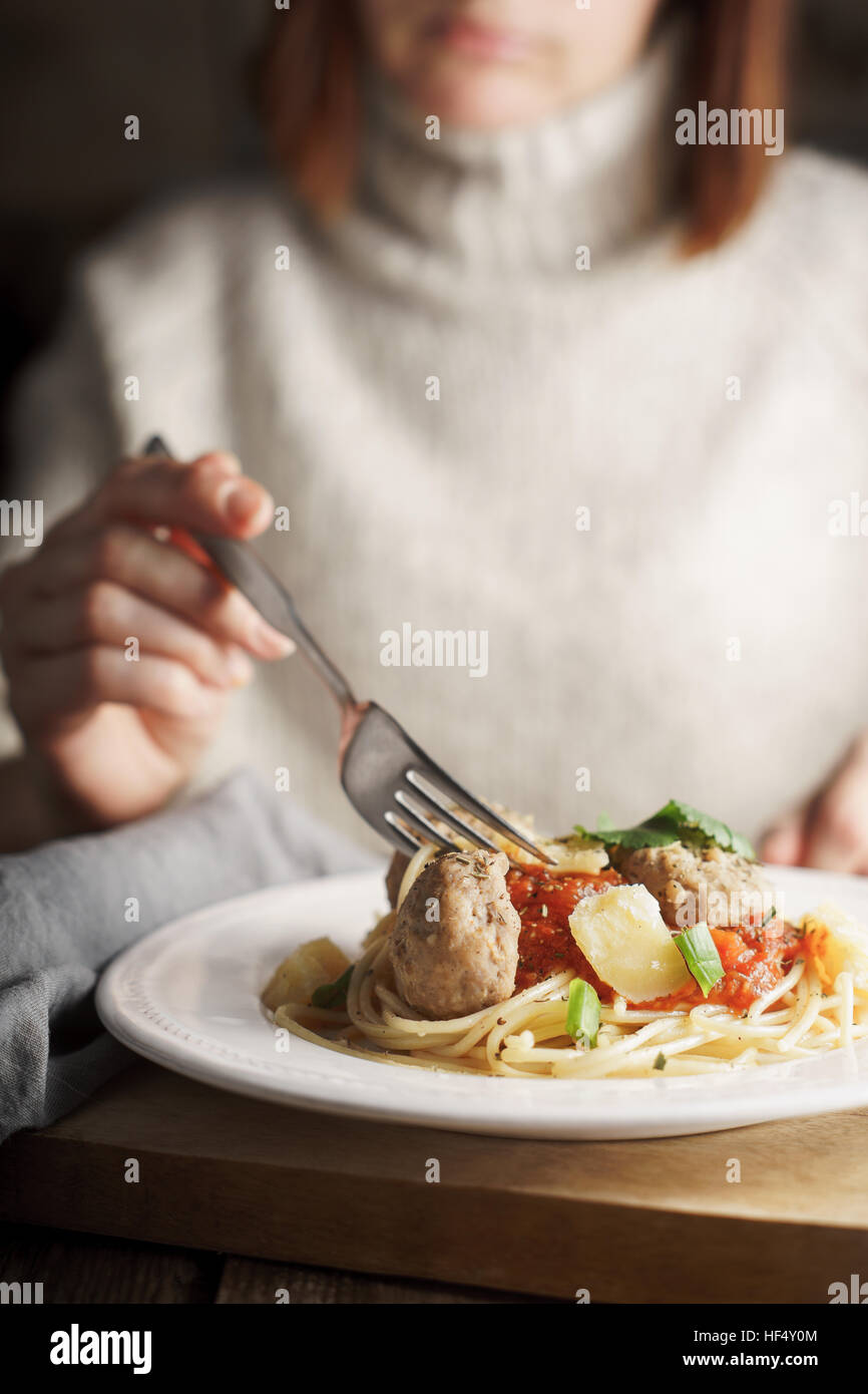 Frau Essen Spaghetti mit Fleischbällchen vertikale Stockfoto